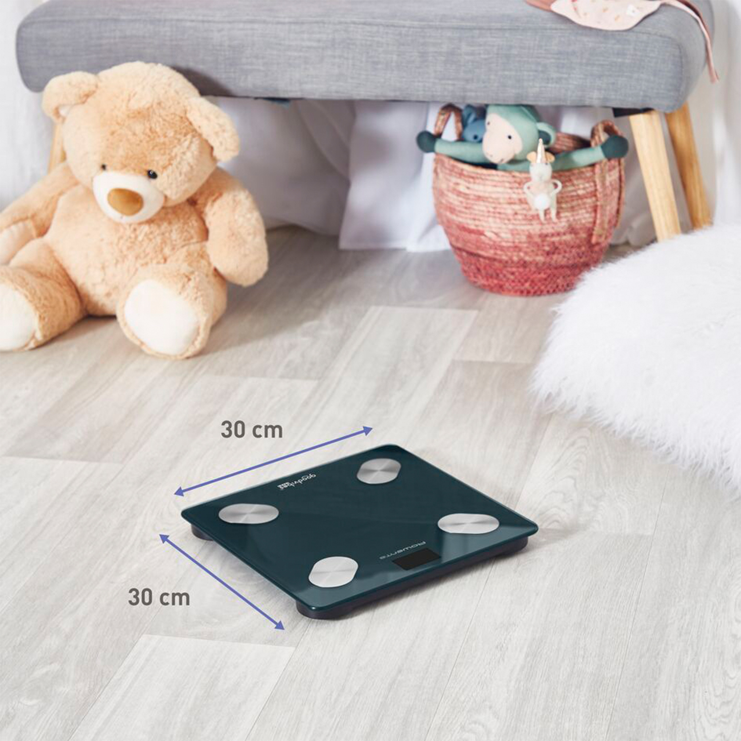 Ciemnozielona waga łazienkowa na jasnej drewnianej podłodze, 30x30 cm.