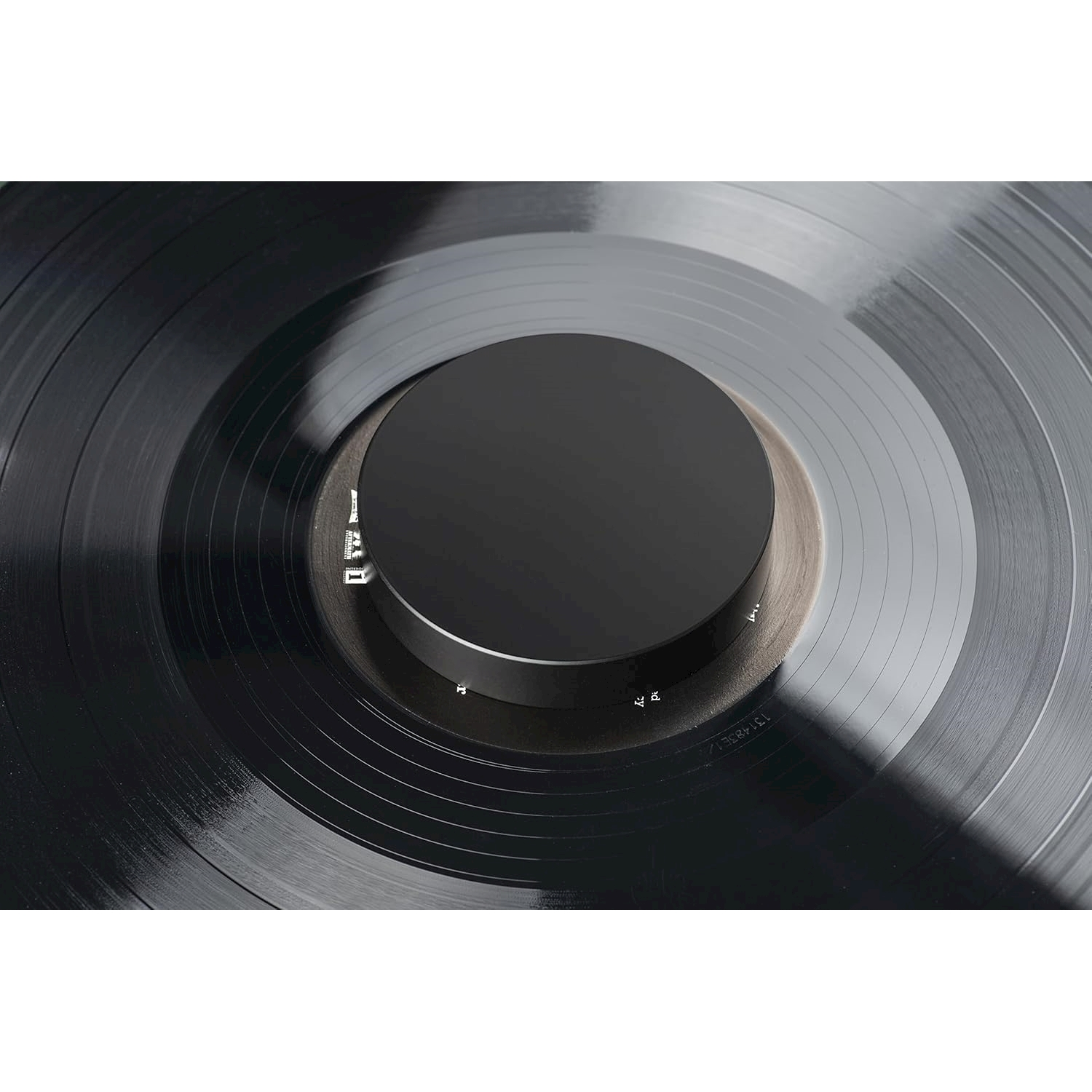 Een zwarte vinylplaat met een zwarte centrale spil en groeven.