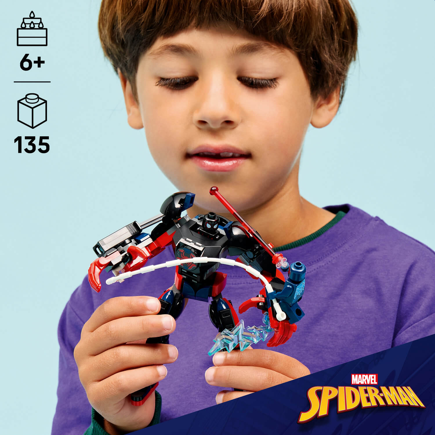 Un niño sostiene una figura de Spider-Man con elementos rojos y negros y una telaraña blanca.