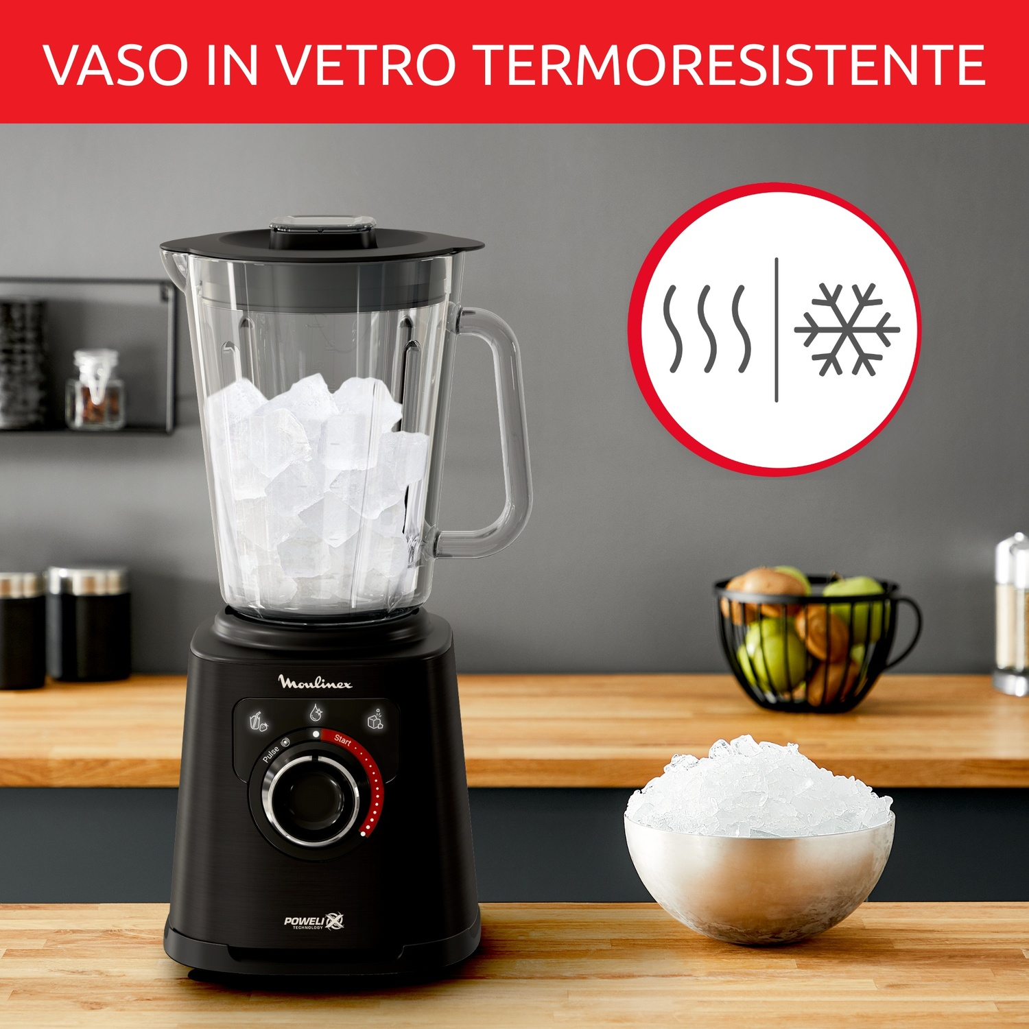 Un frullatore nero con ghiaccio nel boccale di vetro si trova su un bancone di legno.