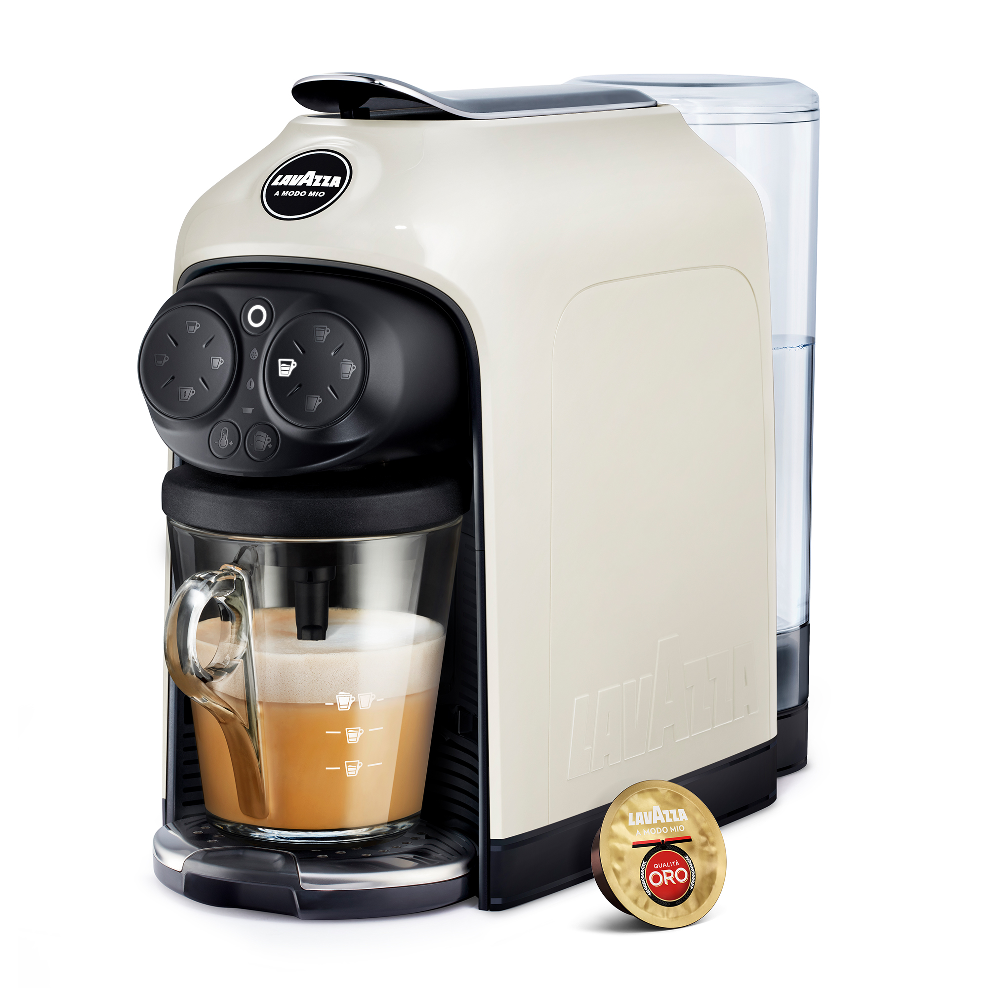 Eine cremefarbene Lavazza Kaffeemaschine mit einem Glas Espresso und einer Kapsel daneben.