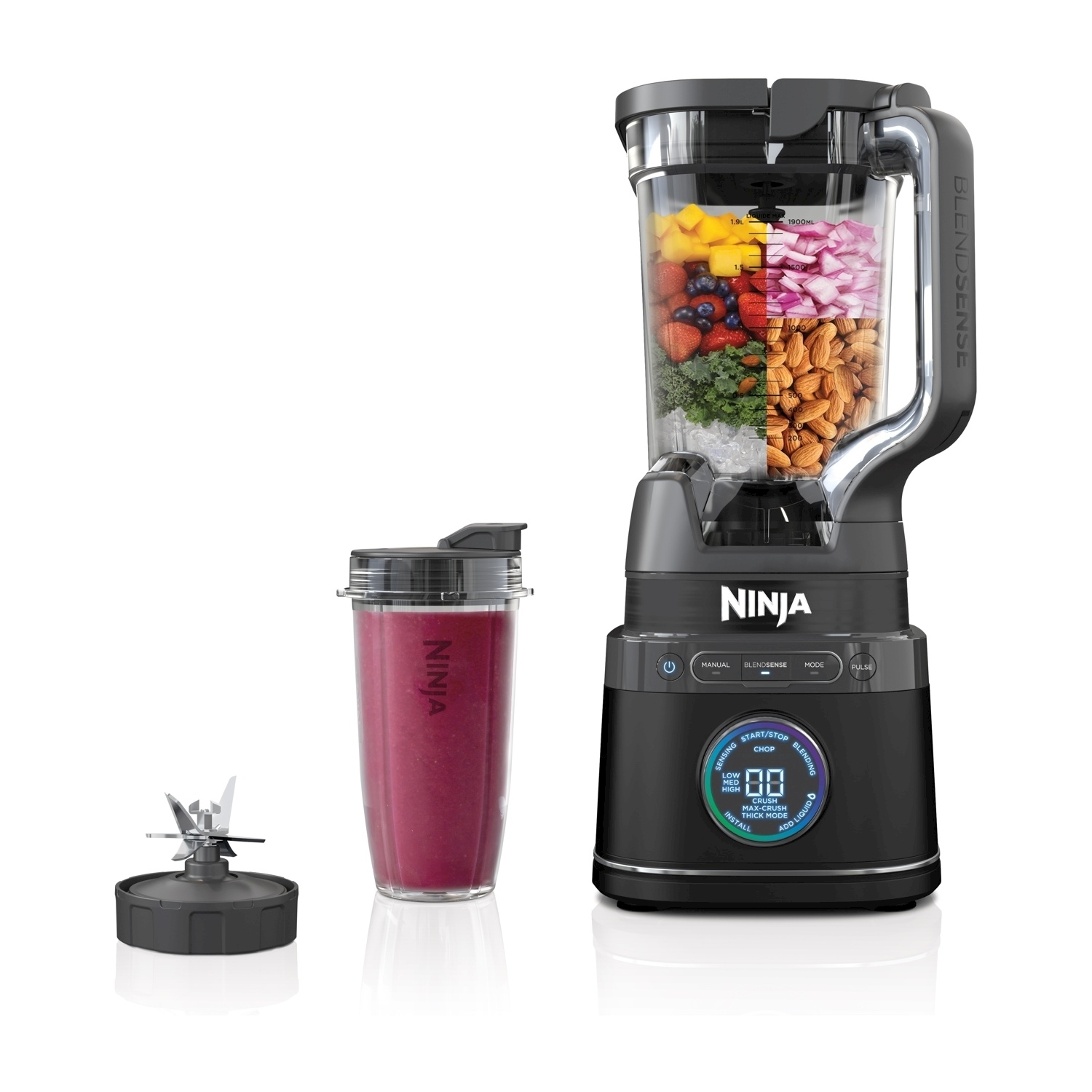Malzemelerle dolu sürahi, smoothie bardağı ve bıçakları olan siyah Ninja blender.