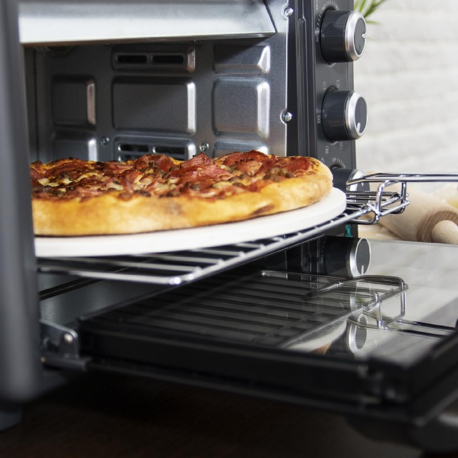 Una pizza viene cotta in un tostapane su una griglia.