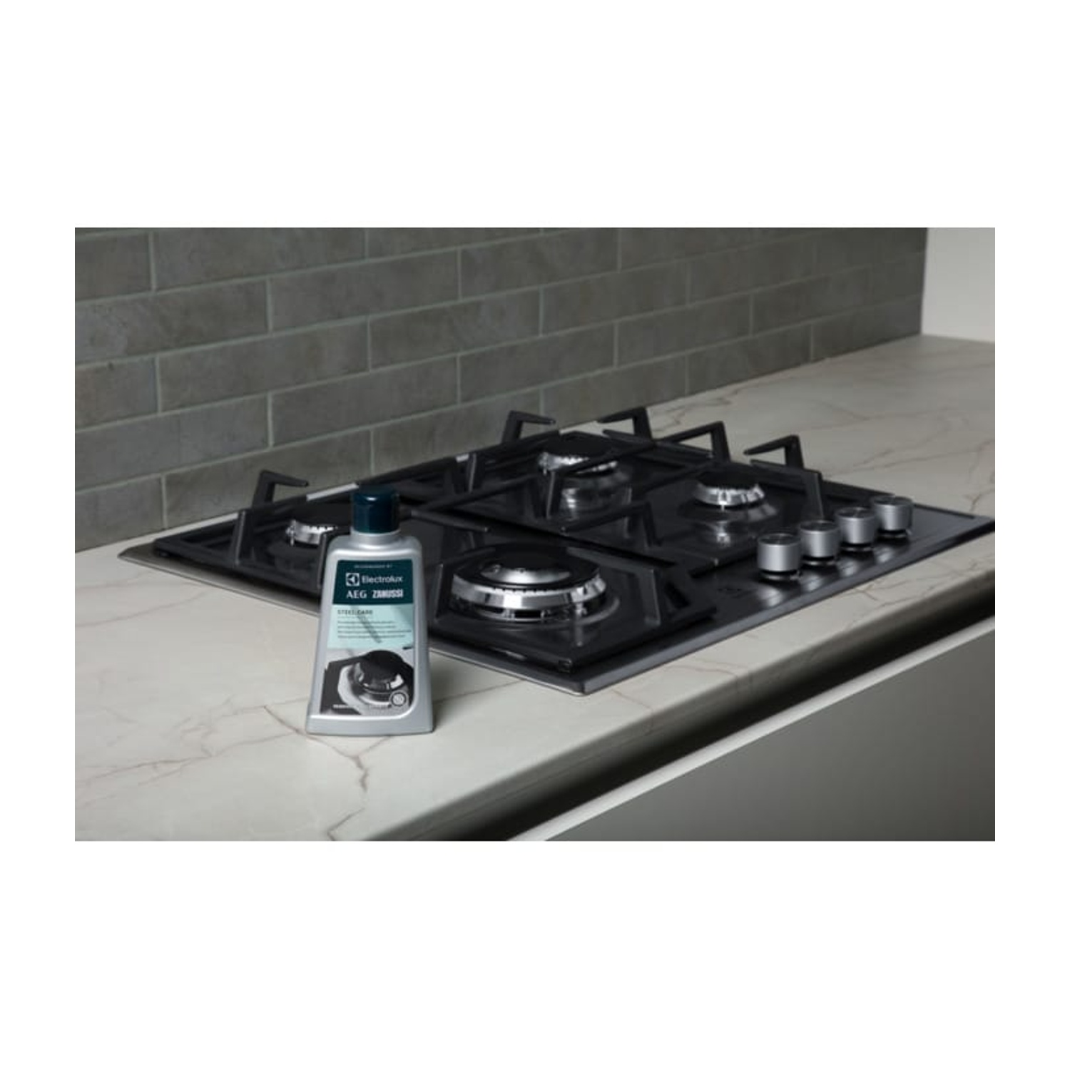 Płyn do czyszczenia butelek na kuchence gazowej z marmurowym blatem i szarą ścianą z płytek.