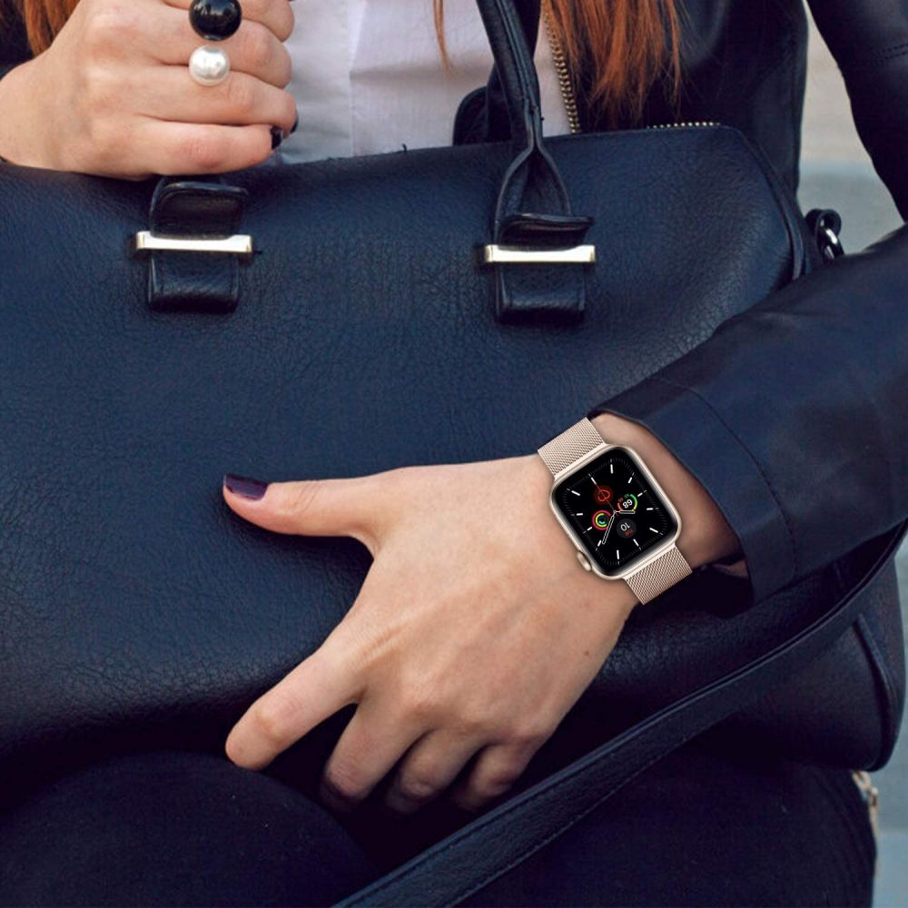 Eine Hand mit einem silbernen Smartwatch und einem schwarzen Lederjacke trägt eine Tasche.