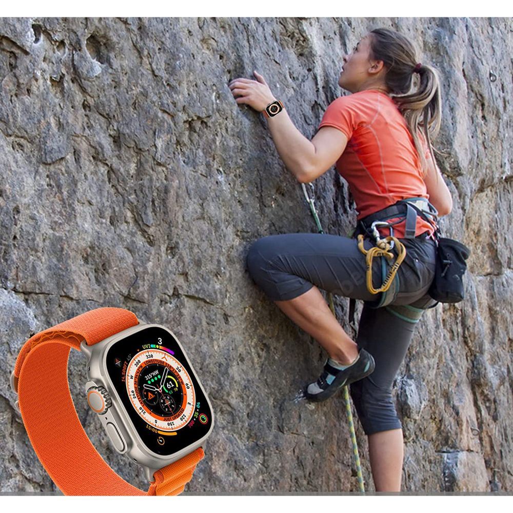 Eine Frau klettert an einem Felsen, eine Smartwatch ist im Vordergrund.