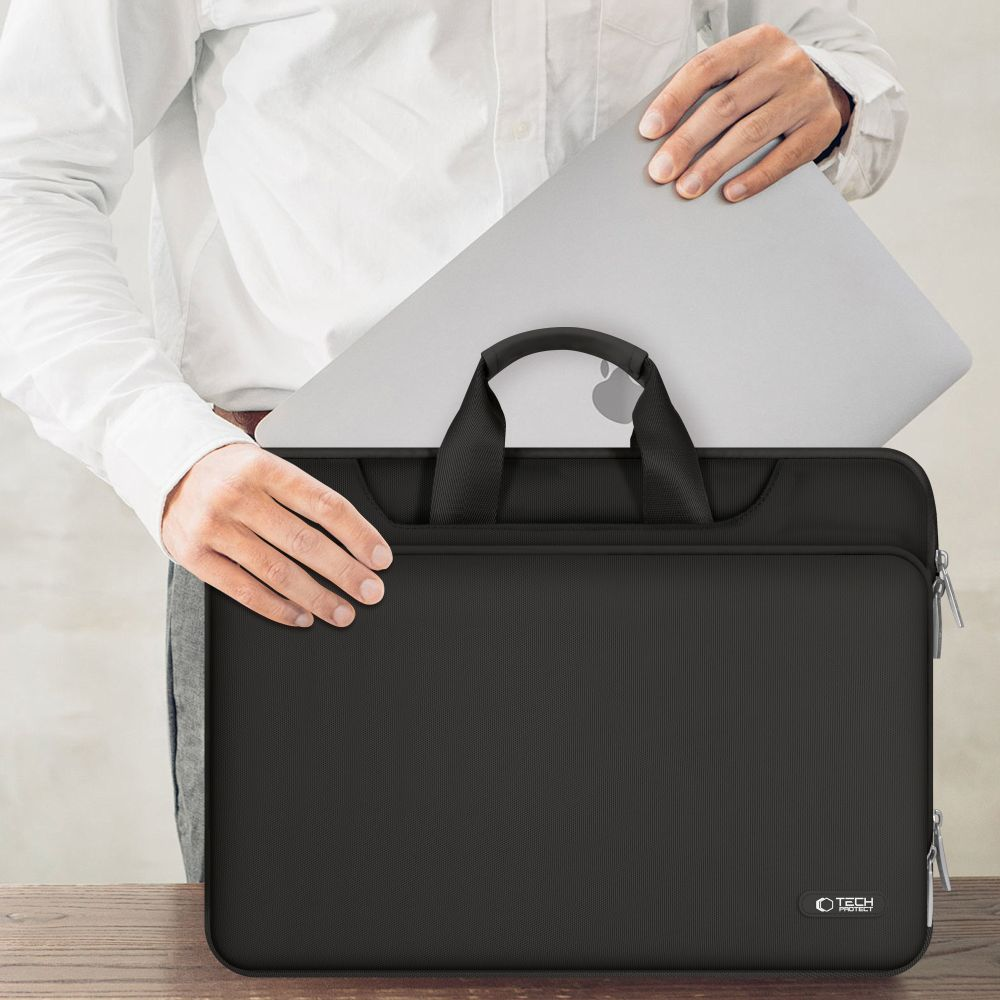 Mann legt Laptop in schwarze Laptoptasche.