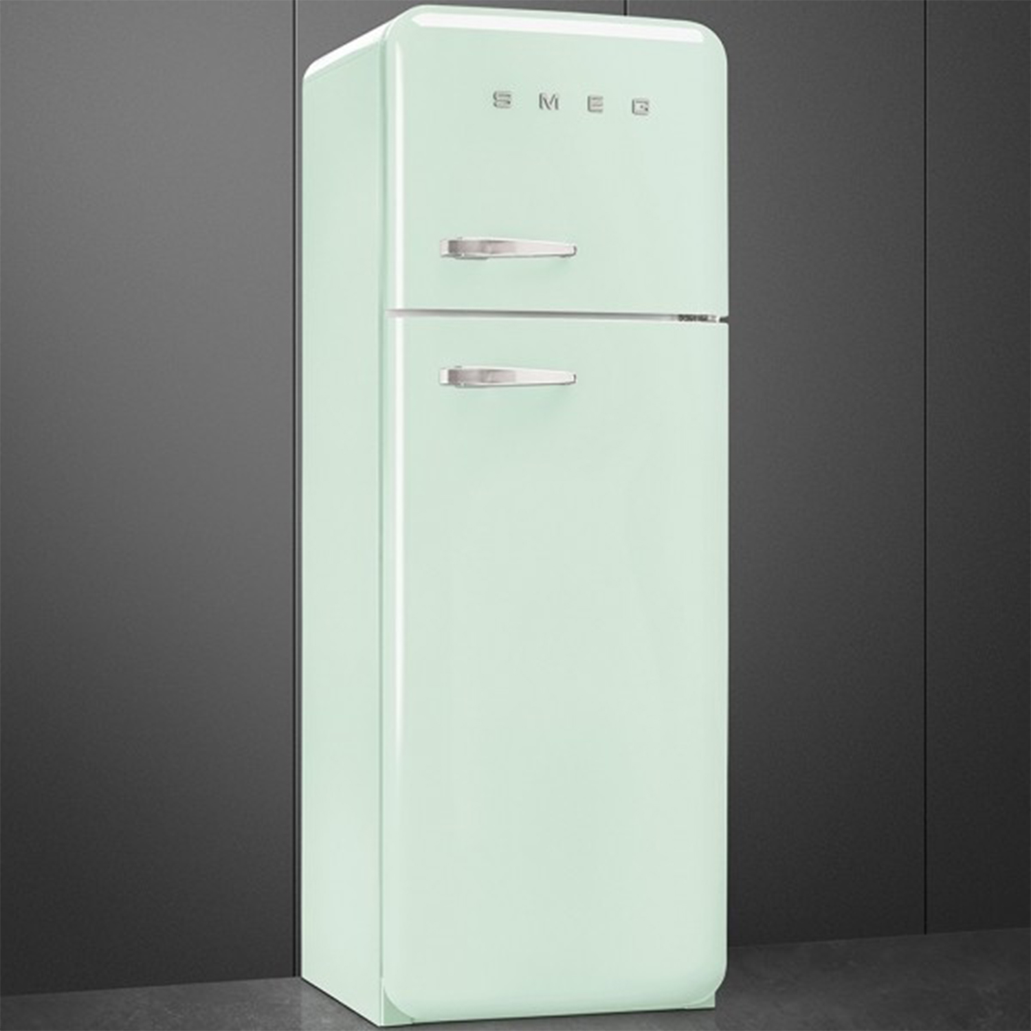 Un refrigerador Smeg verde pálido de dos puertas contra una pared gris.