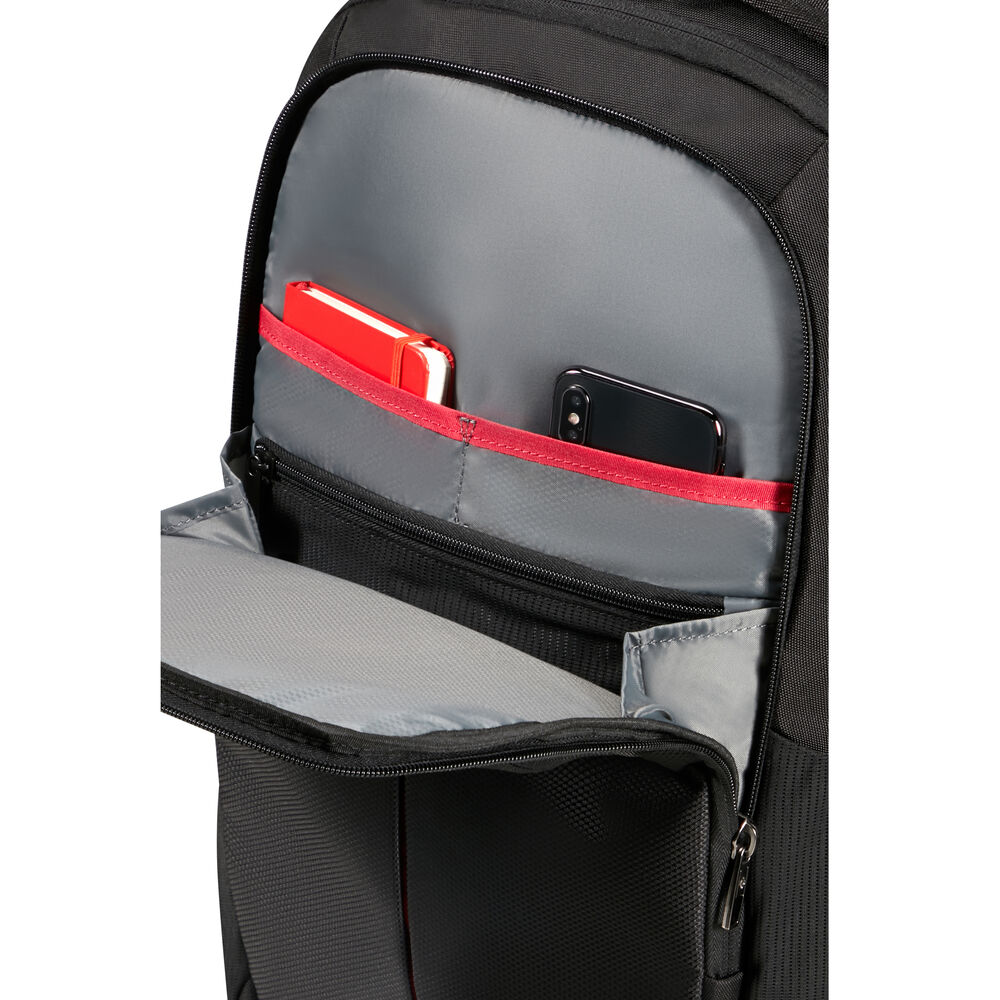 Ein schwarzer Rucksack mit rotem Notizbuch und Handy in einer Tasche.