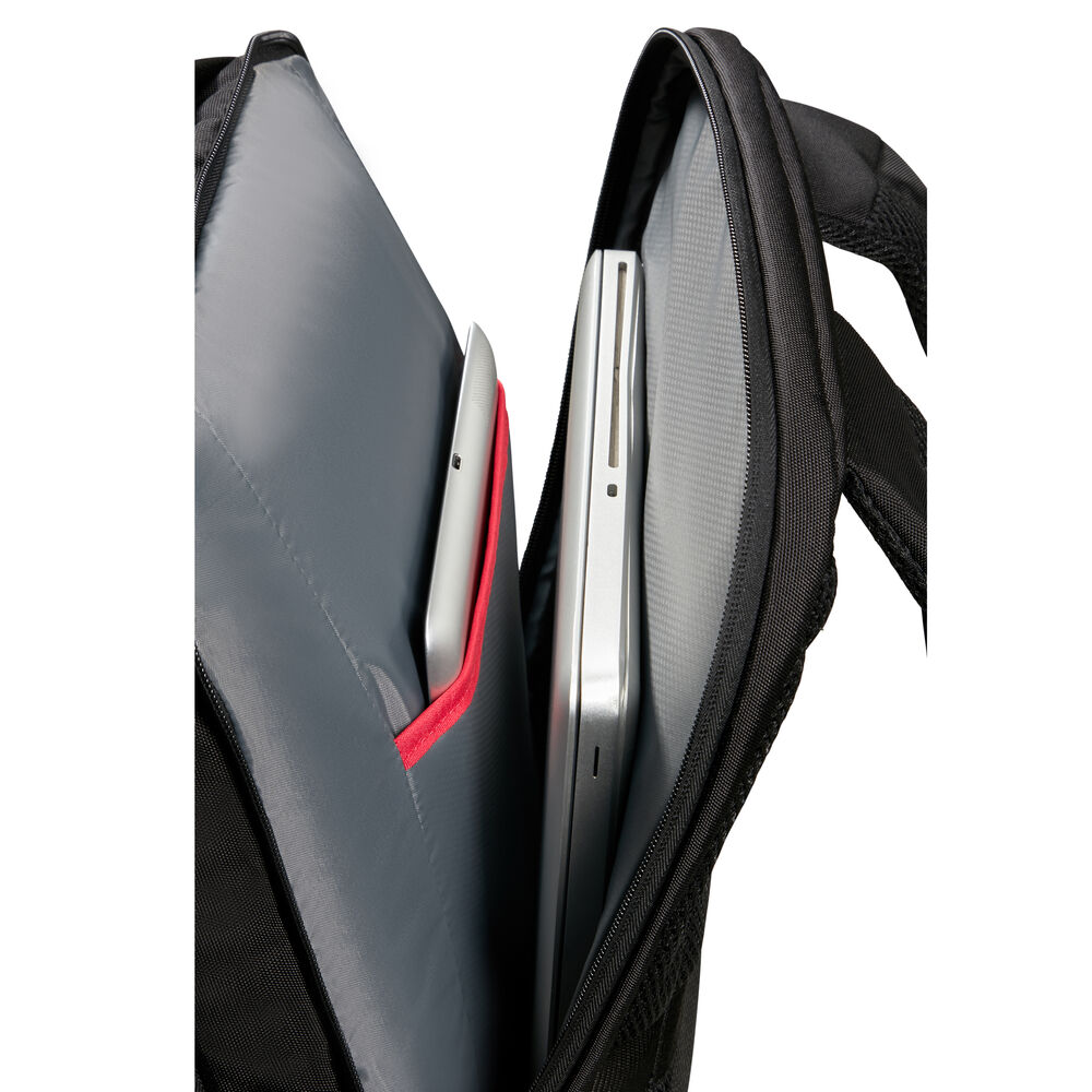 Ein silberner Laptop und ein Tablet befinden sich in den Fächern eines schwarzen Rucksacks.