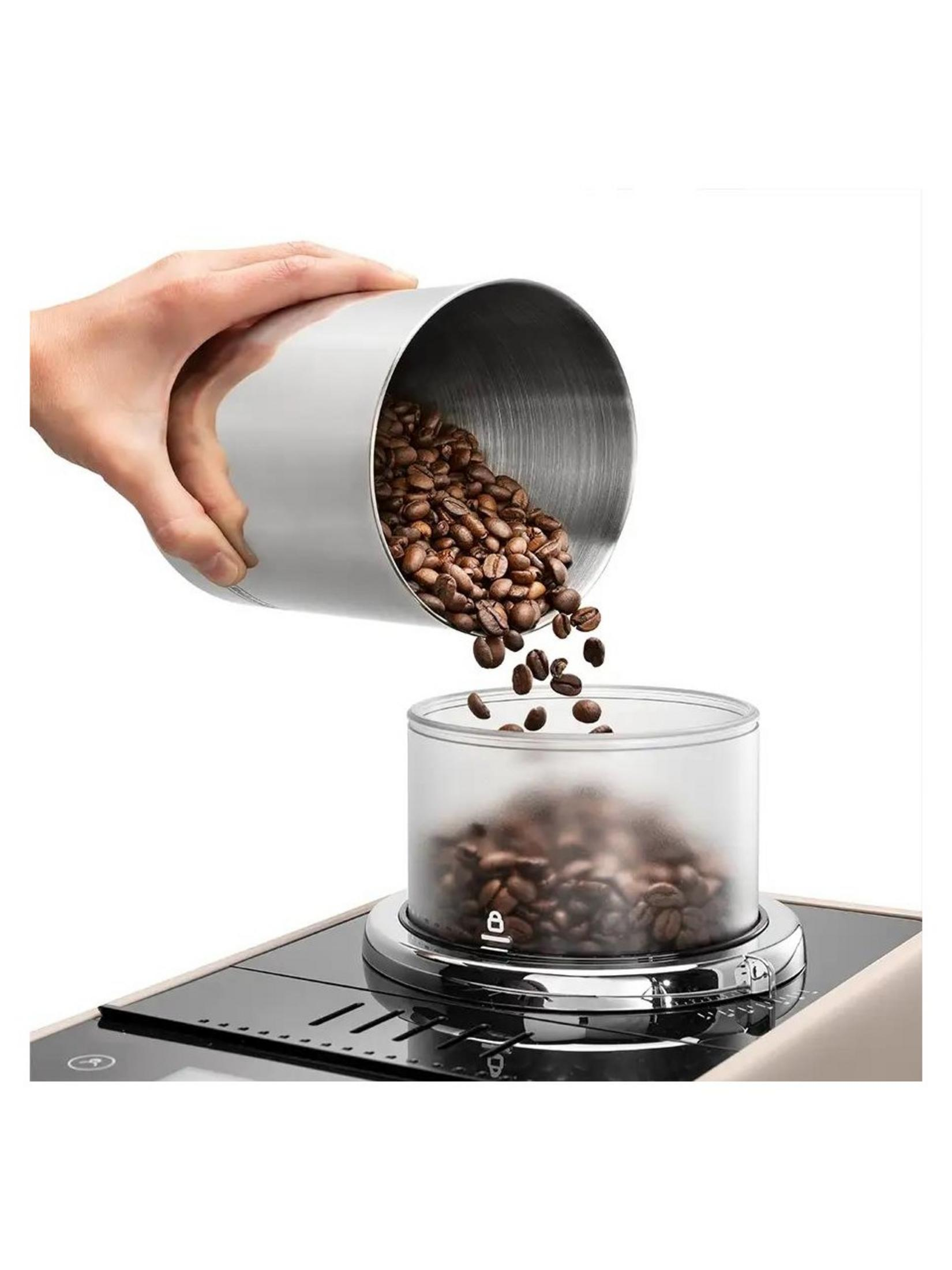 Ręka wsypuje ziarna kawy z metalowego pojemnika do szklanego.