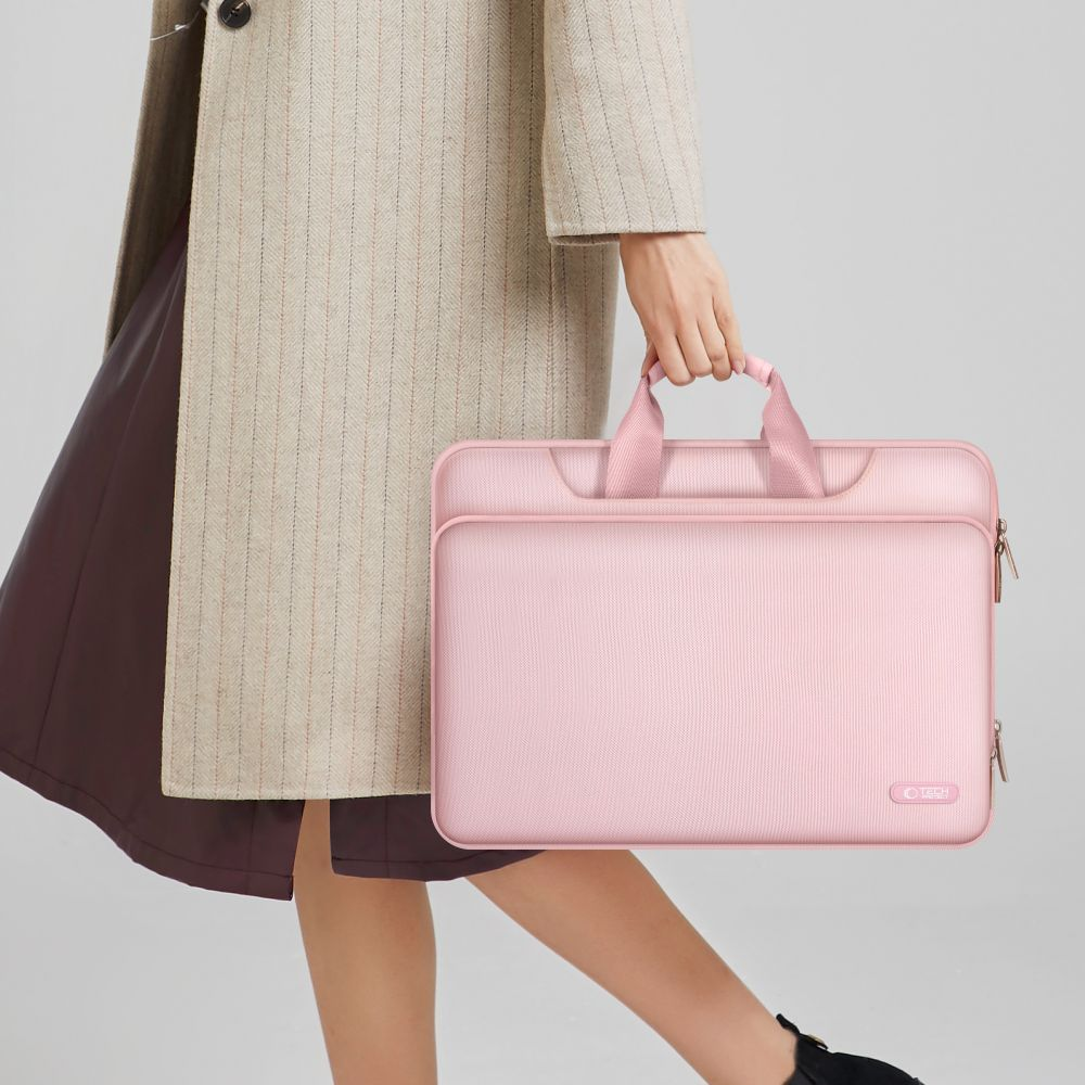 Eine Person hält eine rosafarbene Laptoptasche mit Griffen.