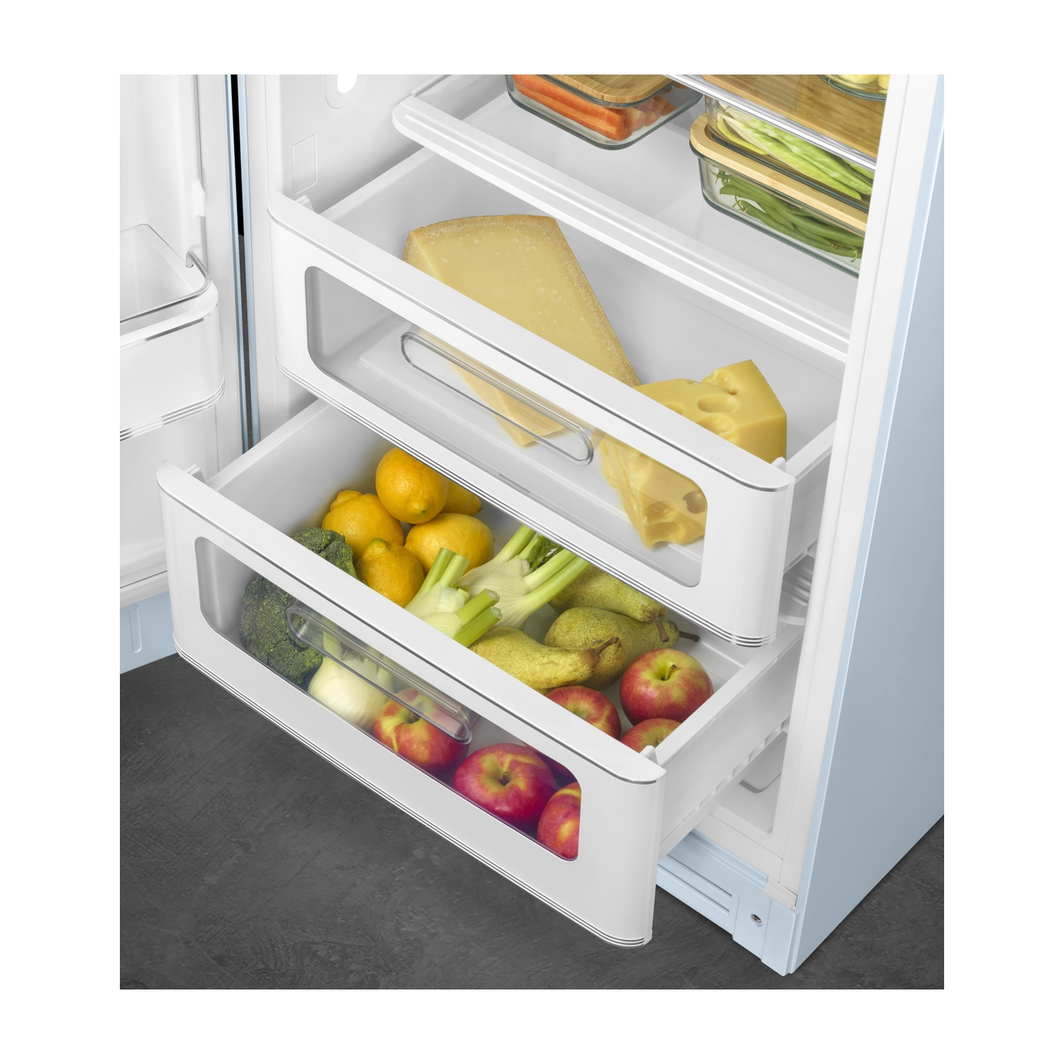 Un refrigerador abierto muestra dos cajones llenos de fruta y queso.