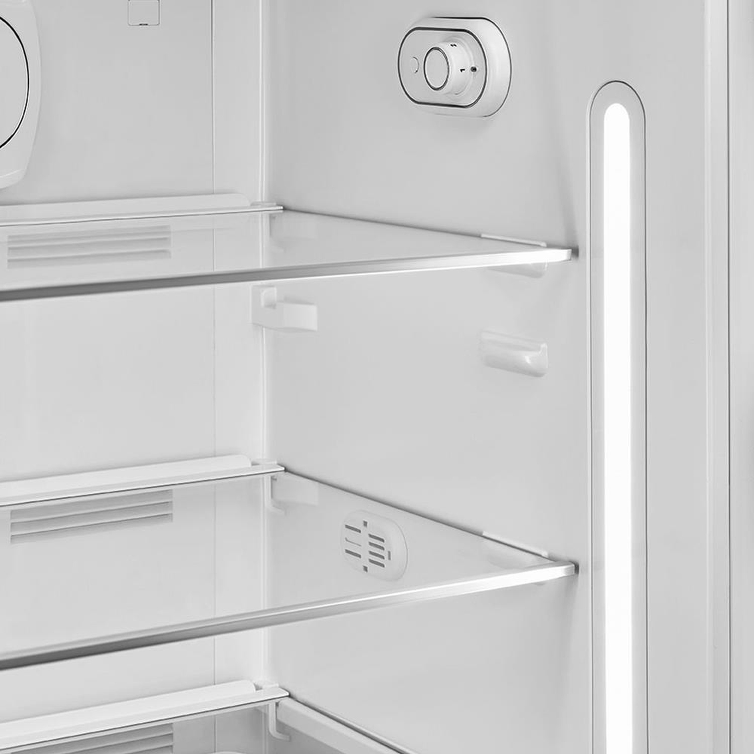 Vista interior de un refrigerador vacío con estantes de vidrio e iluminación LED.