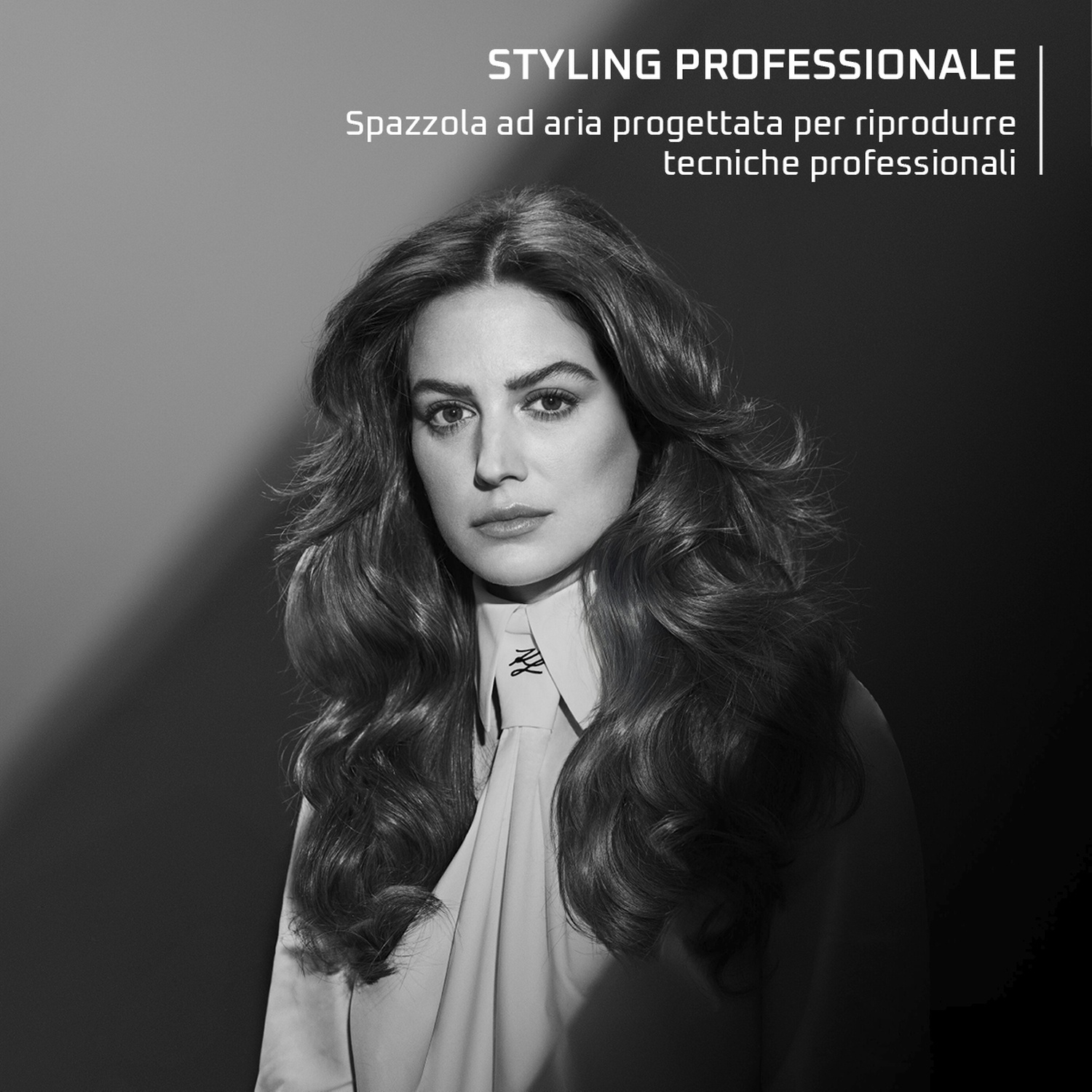 Donna con capelli folti e ondulati e camicia bianca, studio.