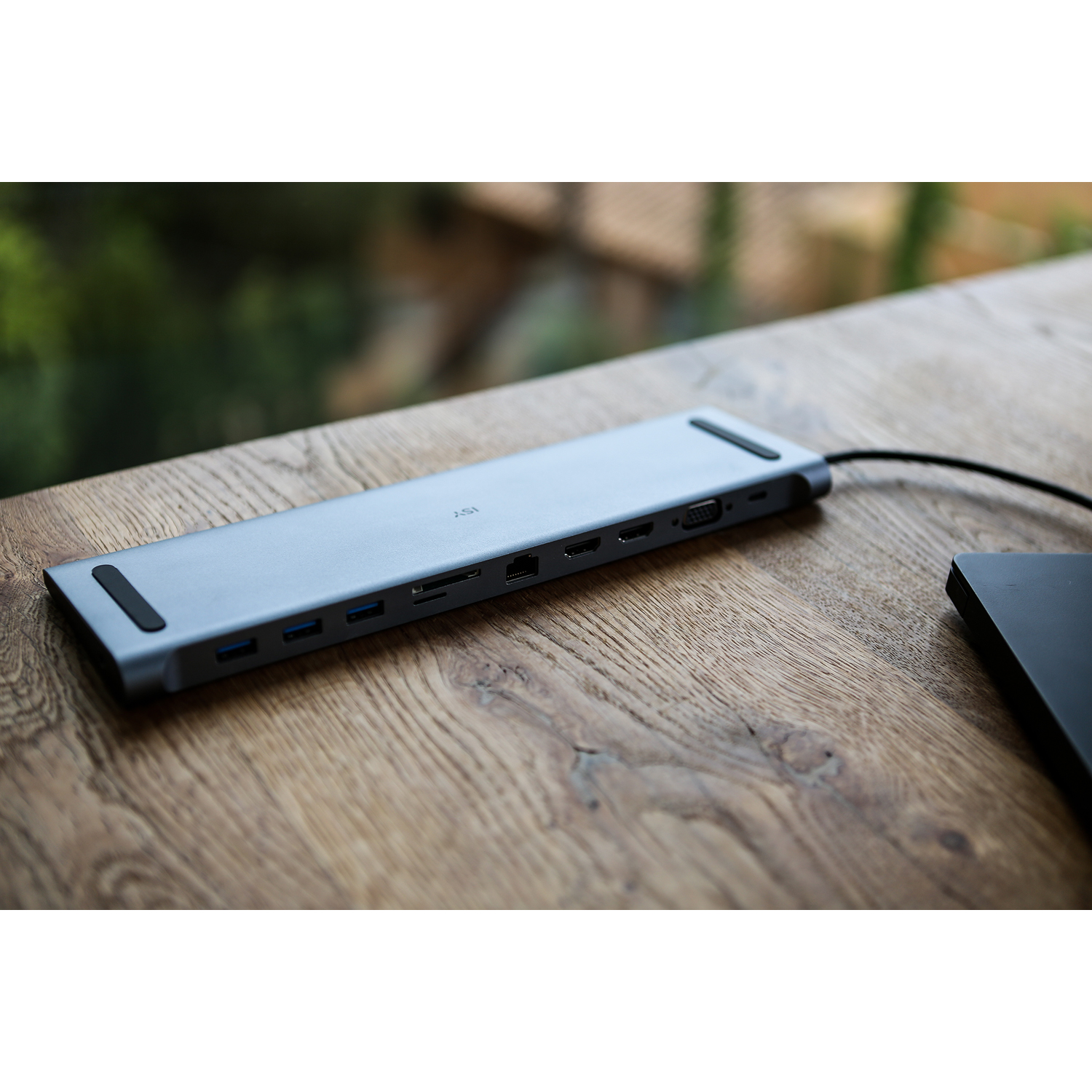 Grauer USB-C-Hub mit Anschlüssen auf einem Holztisch.
