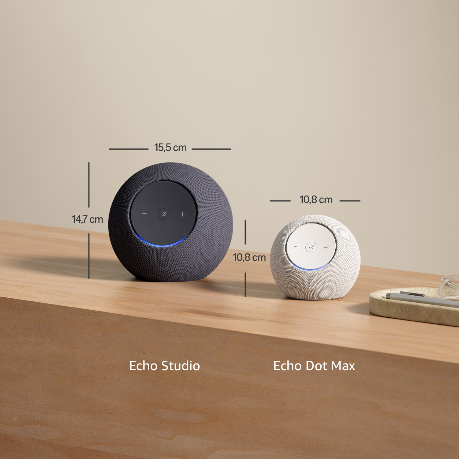 Zwei runde smarte Lautsprecher: Echo Studio (dunkelgrau) und Echo Dot Max (weiß).