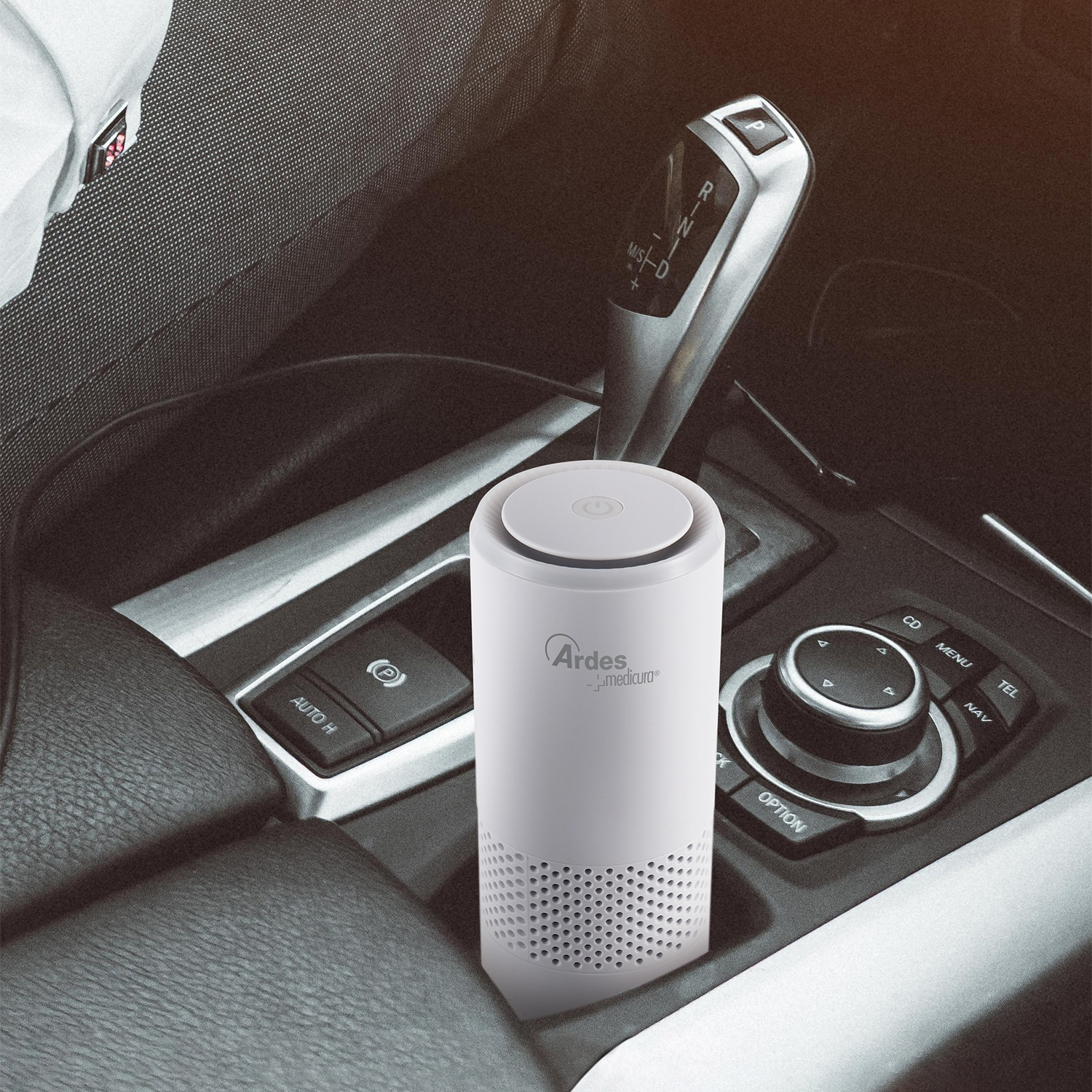 Un purificatore d'aria bianco si trova nella console centrale di un'auto, vicino al cambio.