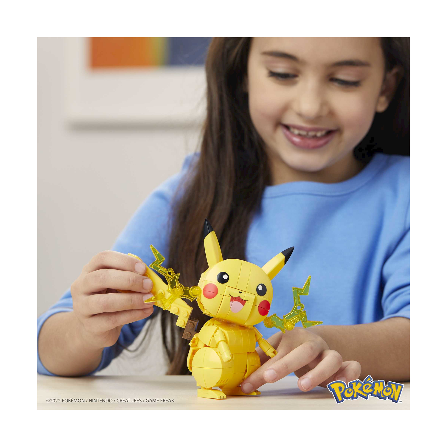 A girl builds a yellow Pikachu toy with lightning accessories.