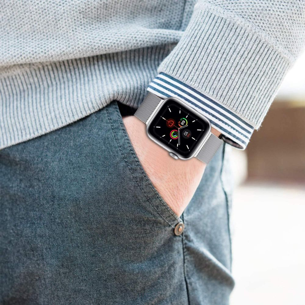 Eine Person trägt eine silberne Smartwatch mit einem Mesh-Armband am Handgelenk.
