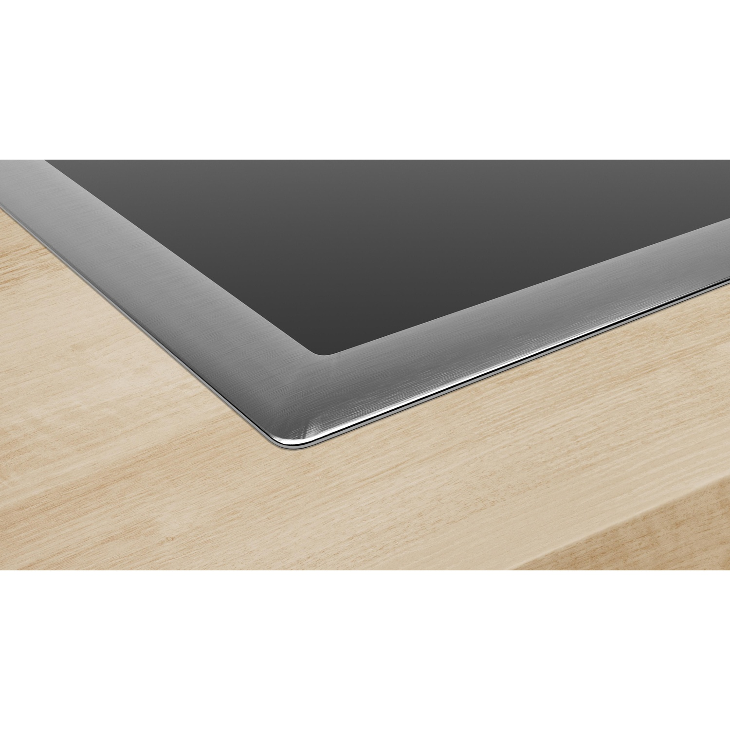 Zbliżenie płyty indukcyjnej ze stalową ramką na drewnianym blacie.