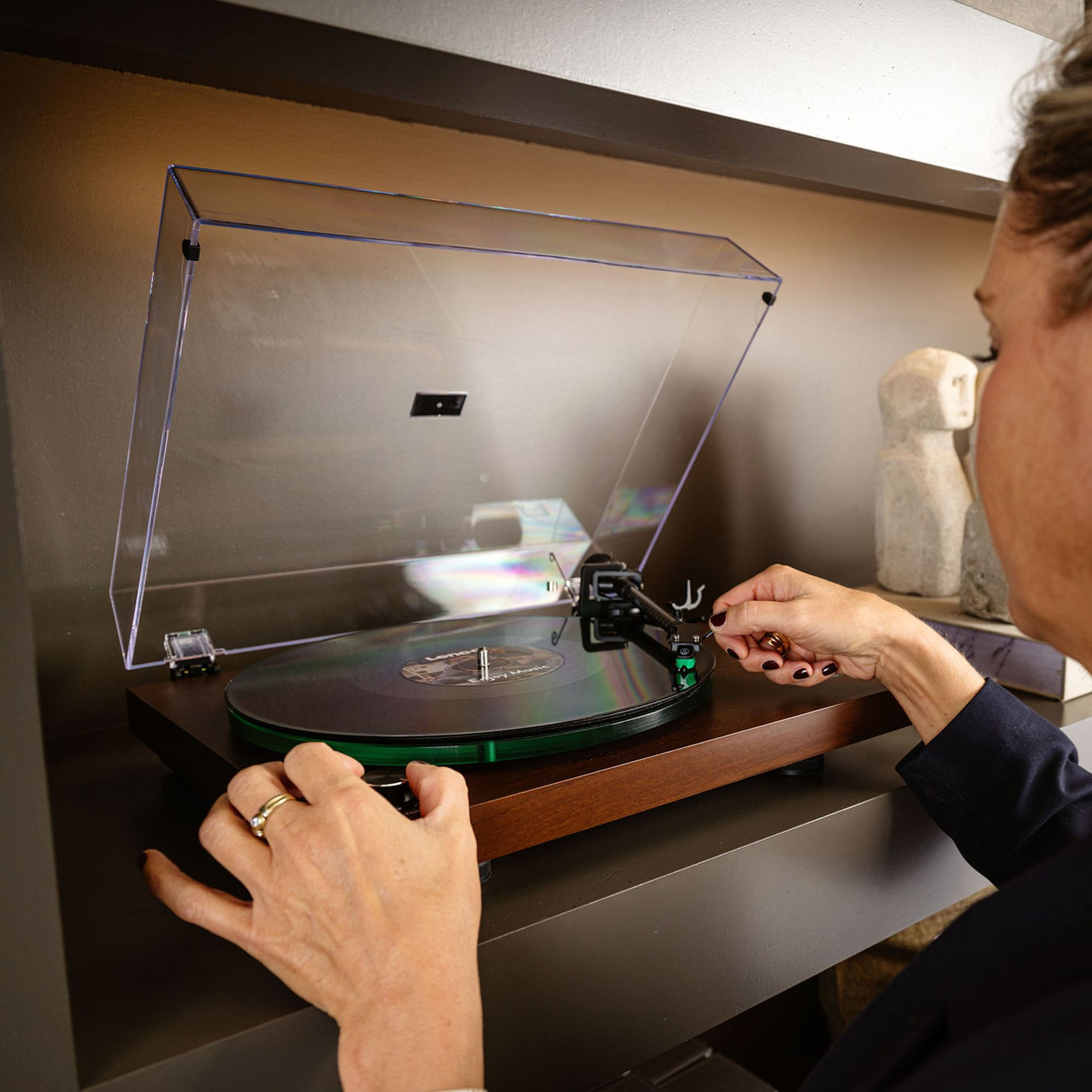 Osoba umieszcza igłę gramofonu na płycie winylowej.