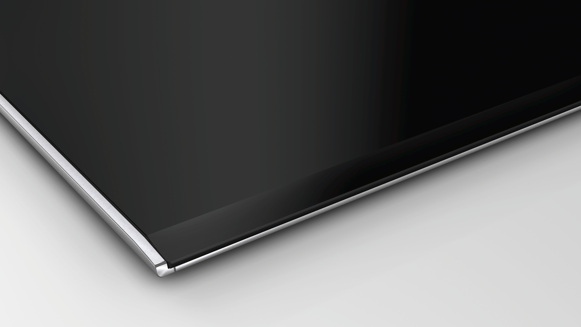 Zbliżenie gładkiej czarnej powierzchni z srebrną krawędzią.