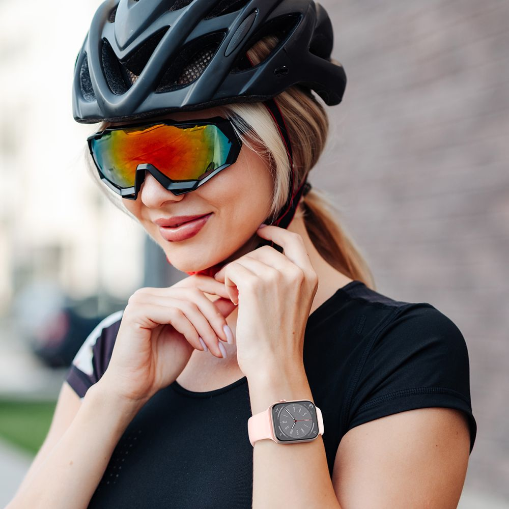 Frau mit Helm, Brille und Smartwatch stellt ihre Ausrüstung ein.