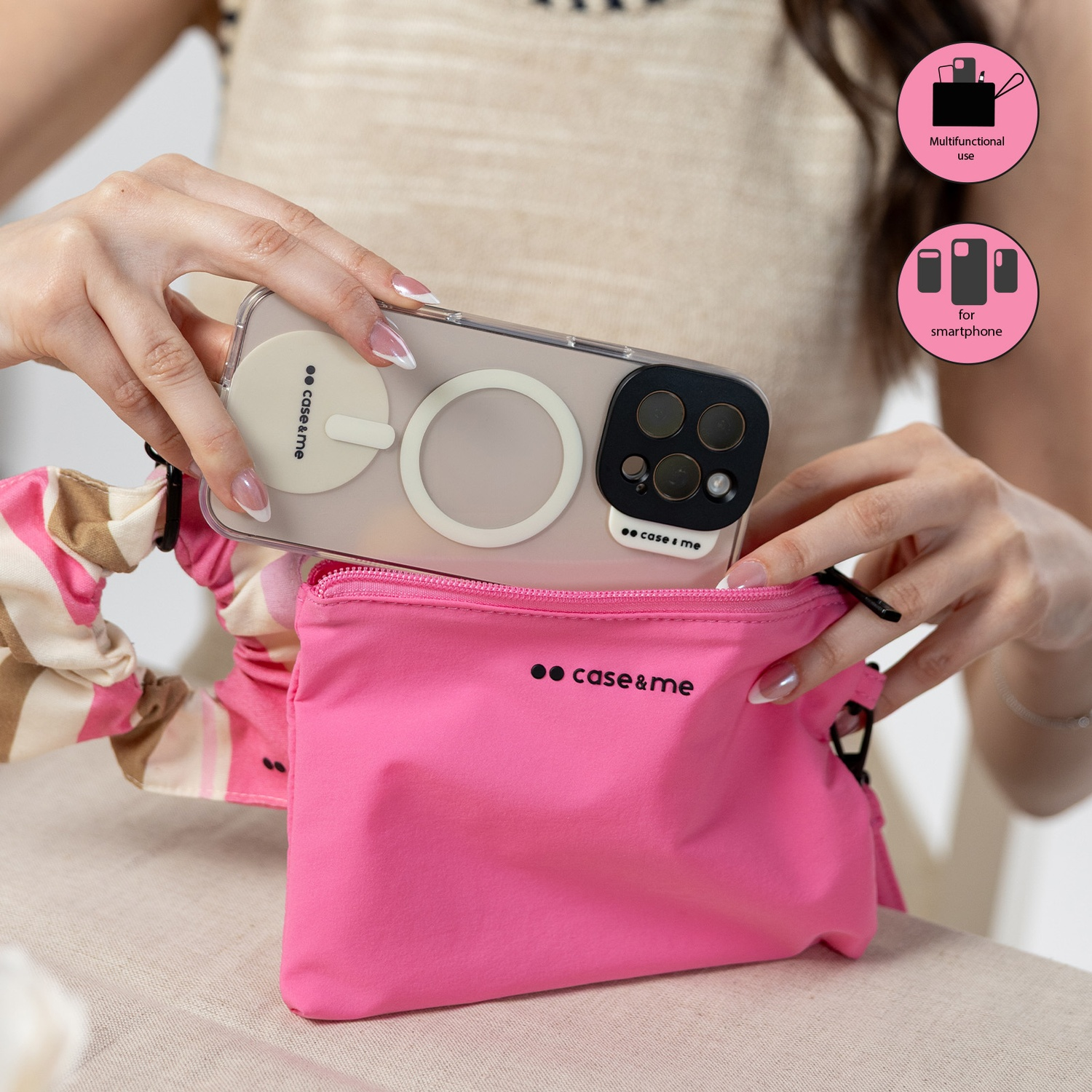 Manos meten un teléfono en un bolso rosa brillante. Se ve una funda de teléfono con anillos.