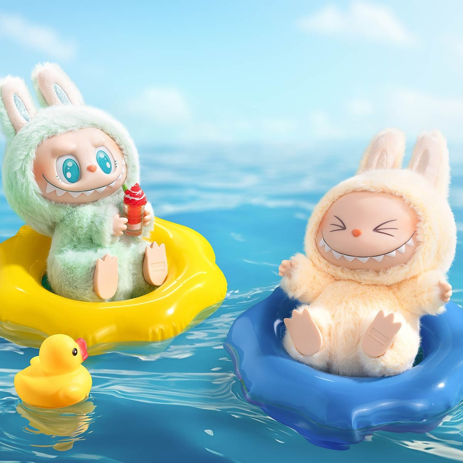 Zwei Plüschtiere in Schwimmringen auf dem Wasser. Eines ist hellgrün, das andere hellgelb.