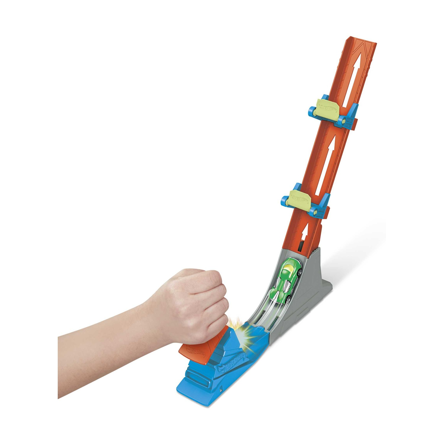 Zielony samochodzik ściga się po torze, gdy ręka go uruchamia.