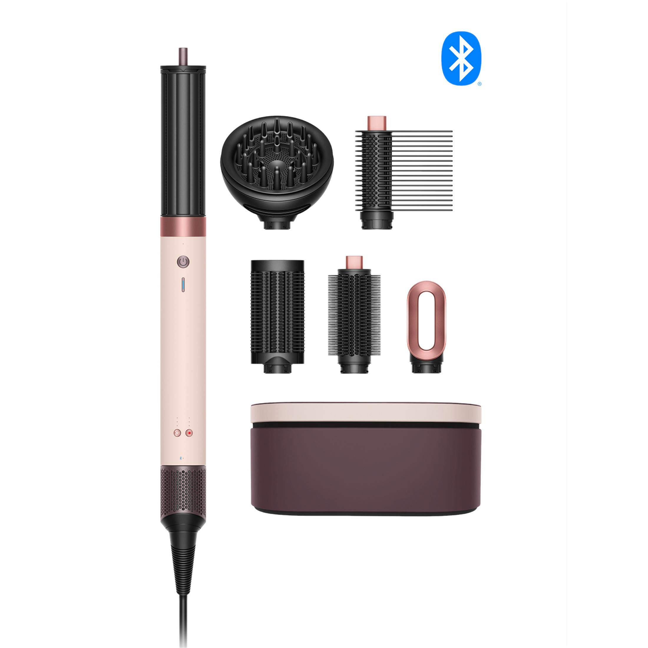 Un asciugacapelli rosa e nero con più accessori e una scatola portaoggetti.