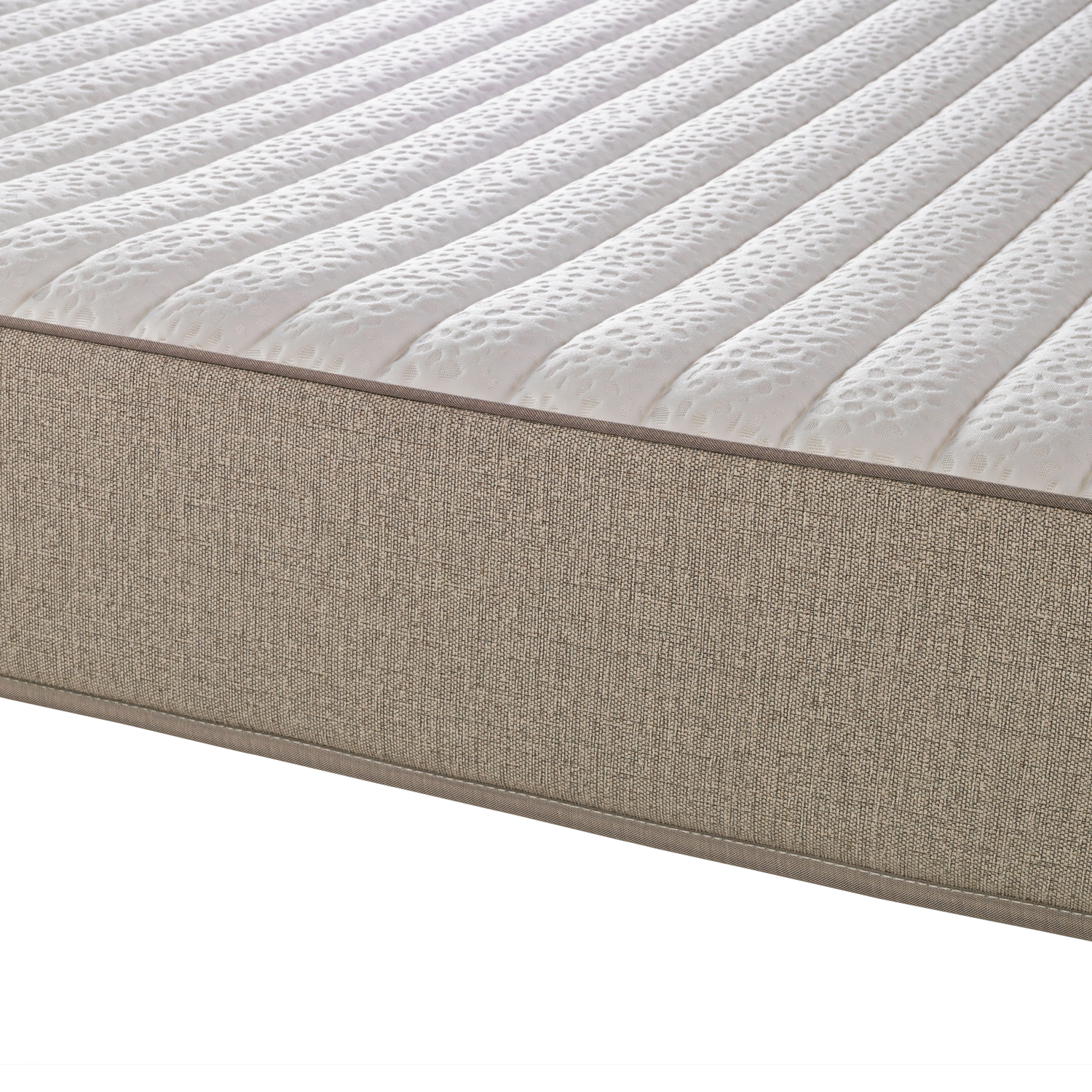 Primer plano de un colchón blanco acolchado con un lateral de tela beige.