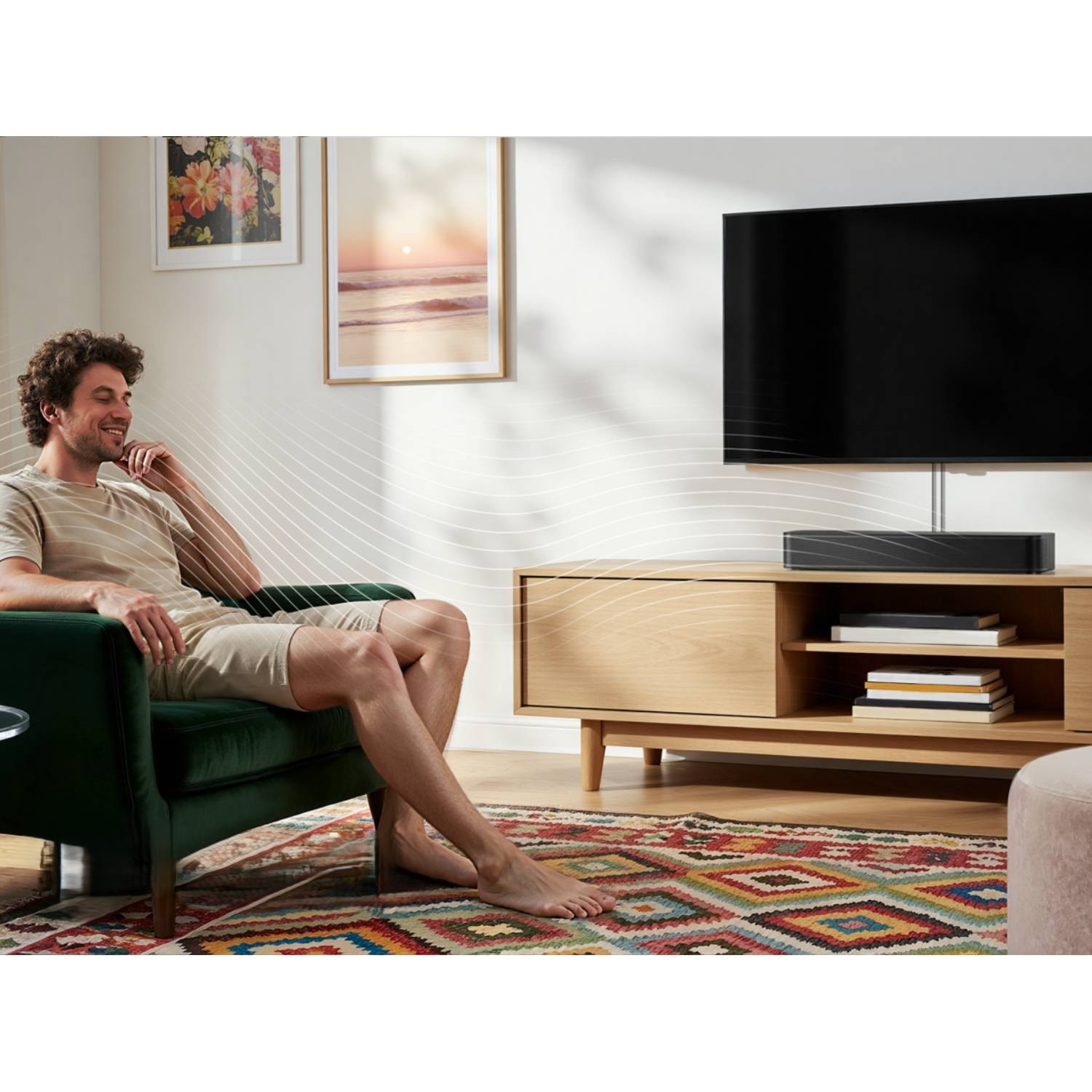 Mężczyzna relaksuje się w fotelu, TV i soundbar w tle.