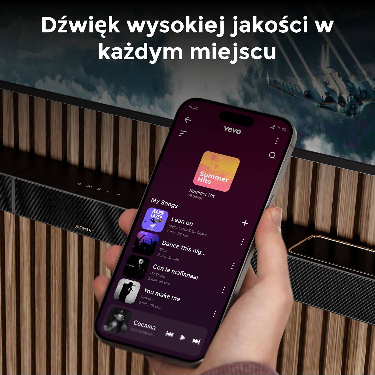 Telefon wyświetla aplikację muzyczną Vevo. W tle widoczna jest soundbar.