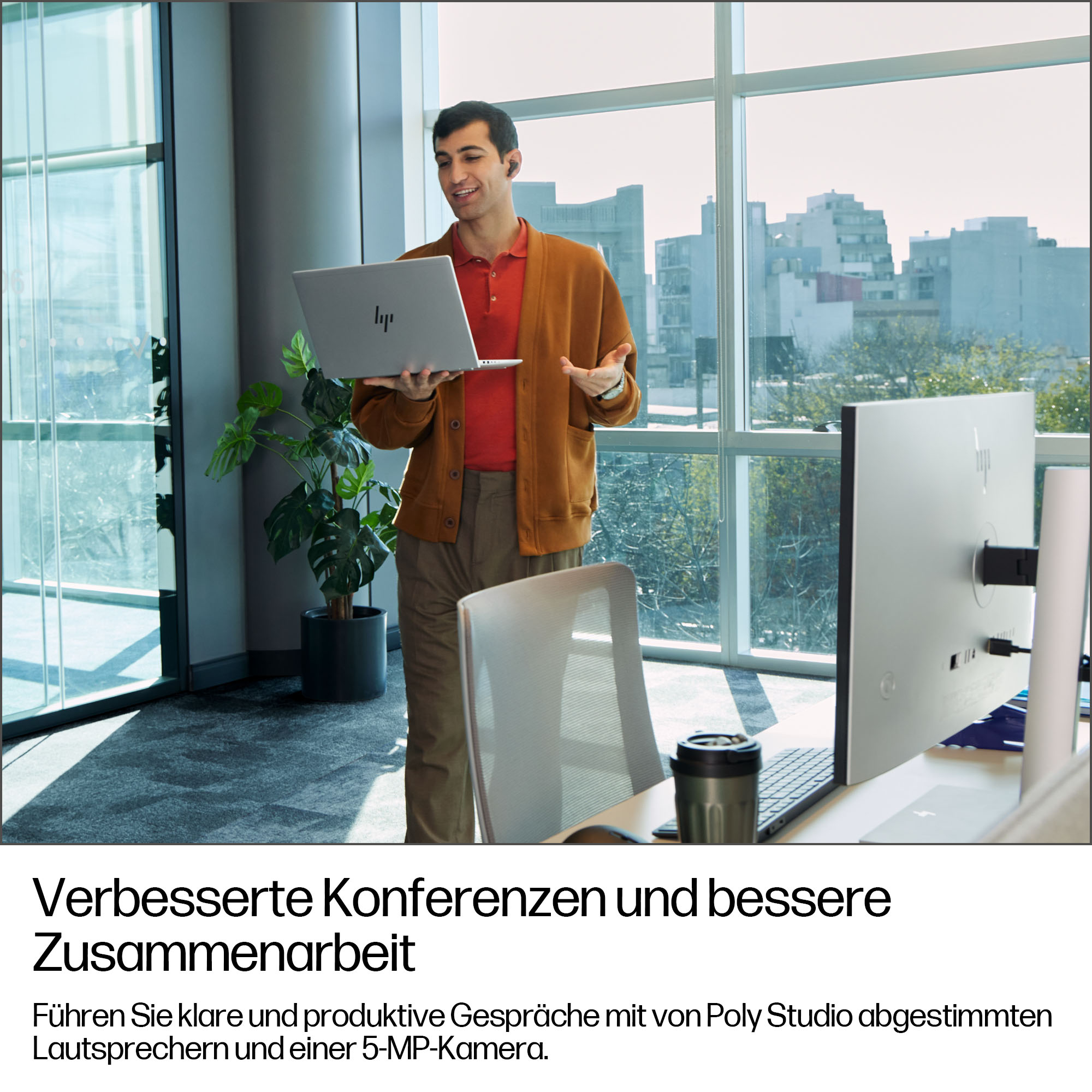 Un uomo con laptop in un ufficio moderno, con due monitor.