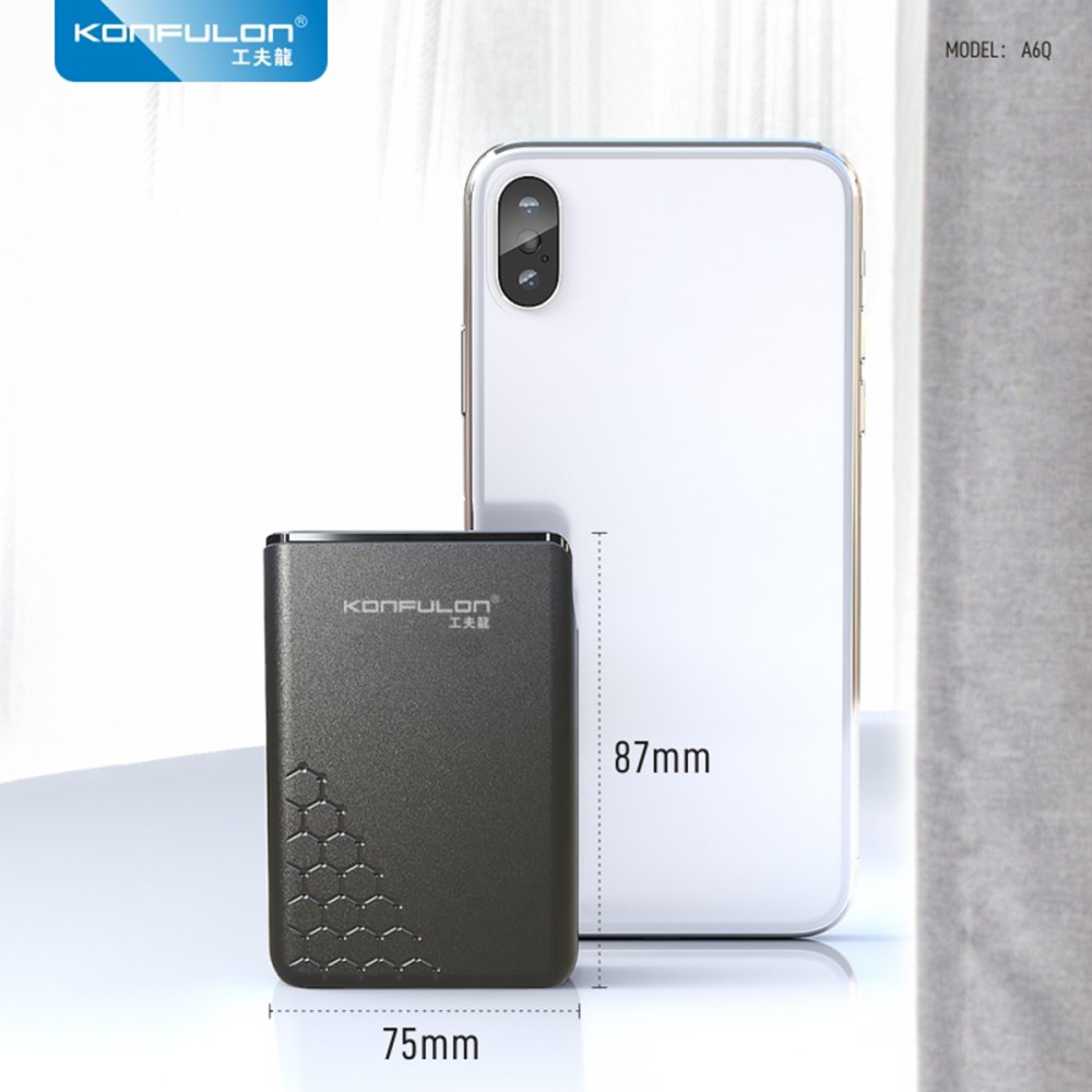 Bal peteği desenli koyu renkli, dikdörtgen bir powerbank, beyaz bir akıllı telefonun yanında.