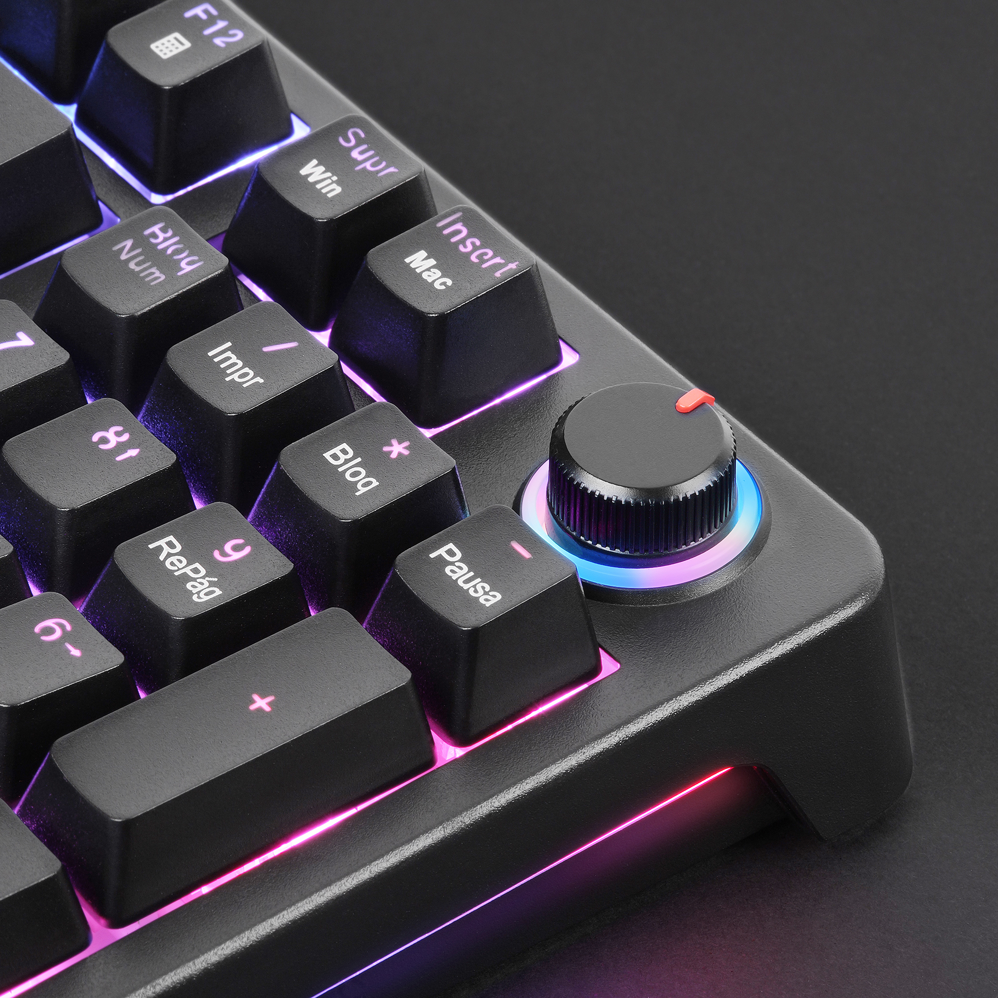 Primer plano de un teclado negro con iluminación RGB y una perilla giratoria.