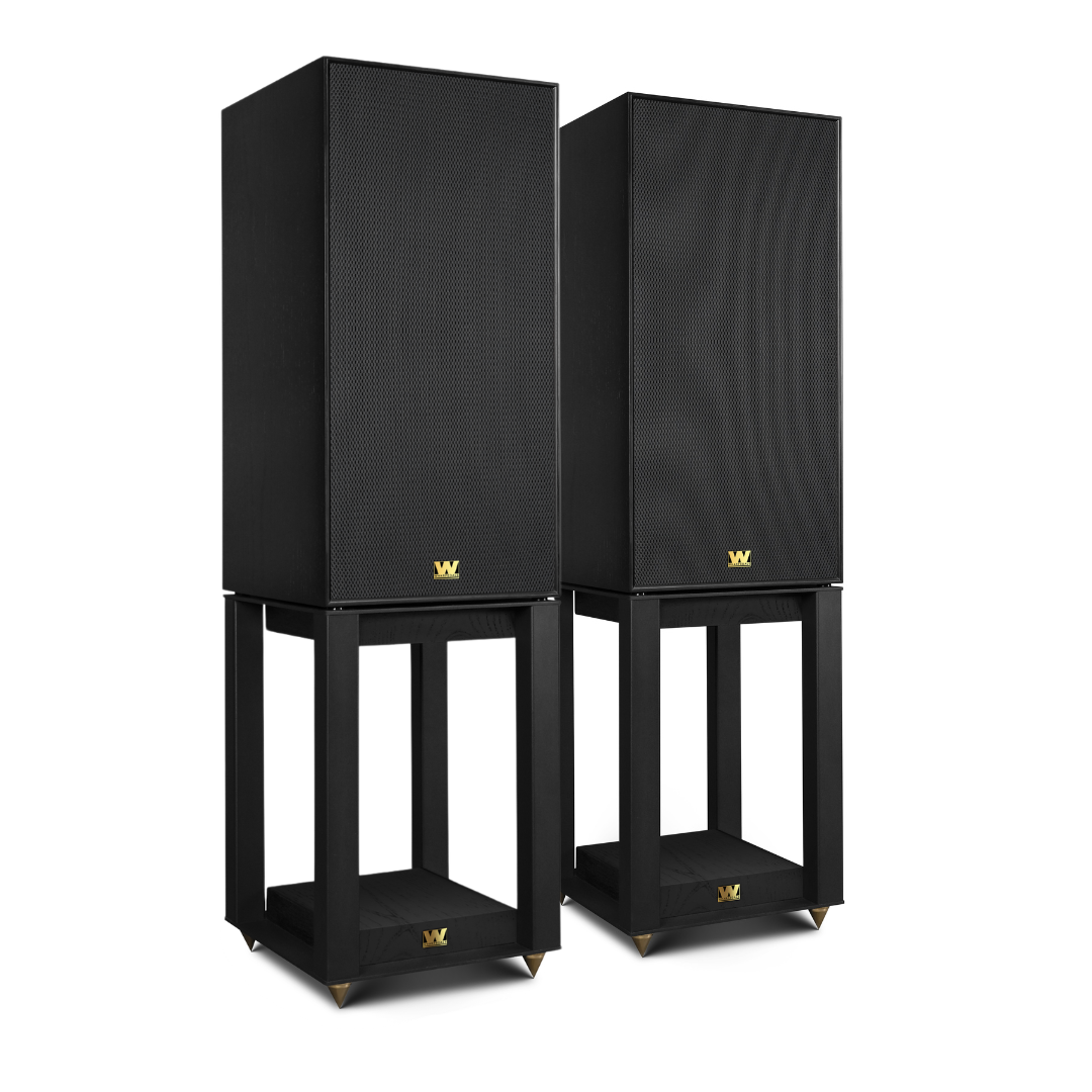 Twee zwarte luidsprekers op zwarte standaards met gouden logo's.