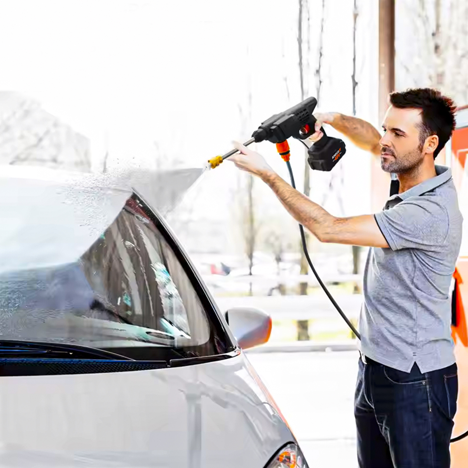 Hombre limpiando coche con hidrolimpiadora portátil.