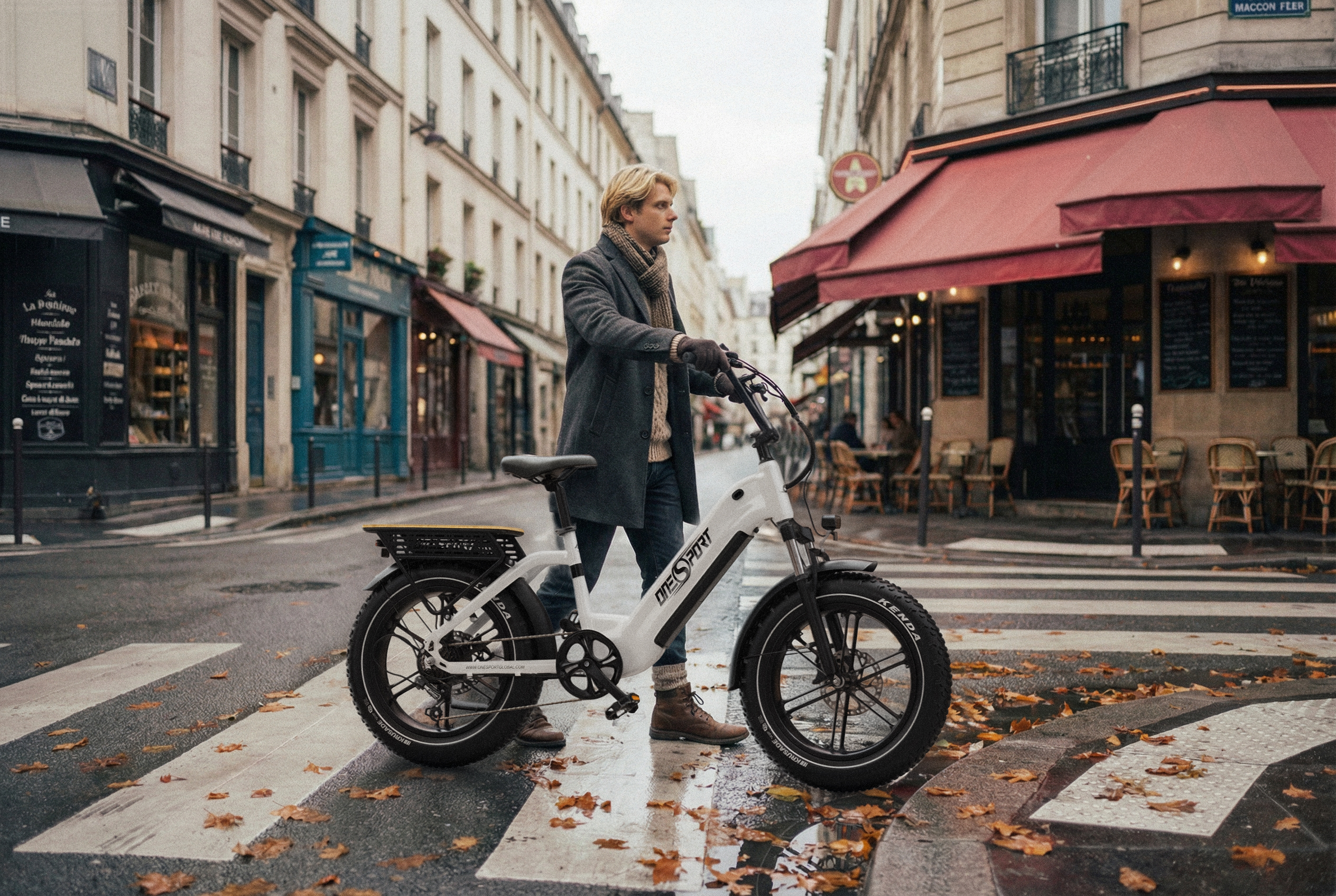 Mężczyzna z białym e-bike na paryskiej ulicy, jesienne liście na ziemi.
