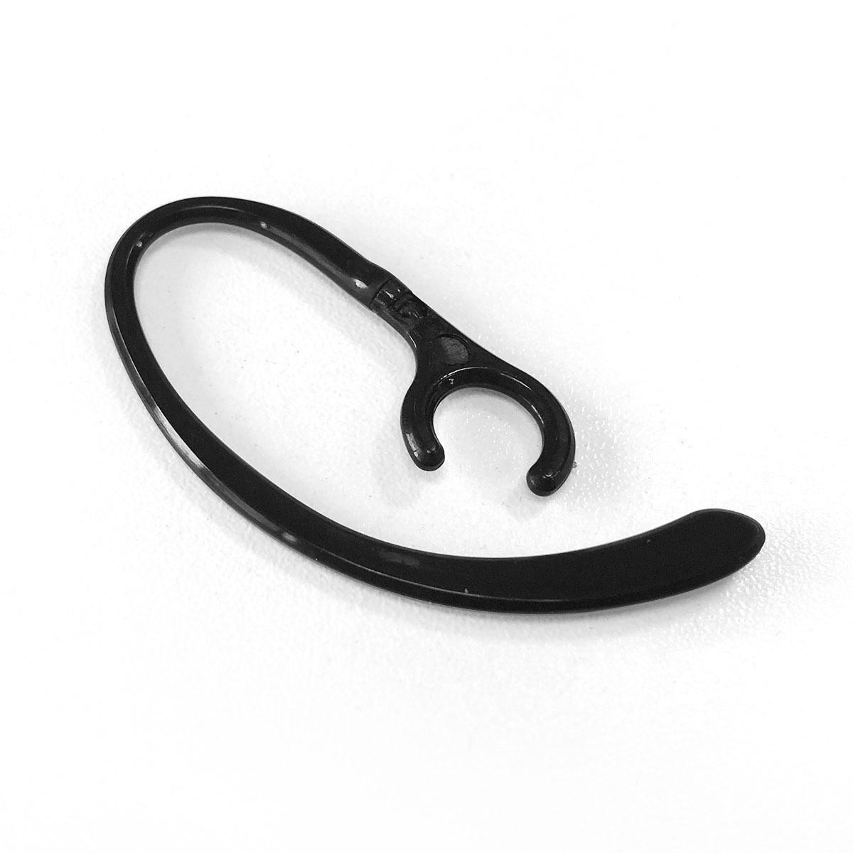 Czarny zaczep na ucho do zestawu słuchawkowego, leżący na białym tle.