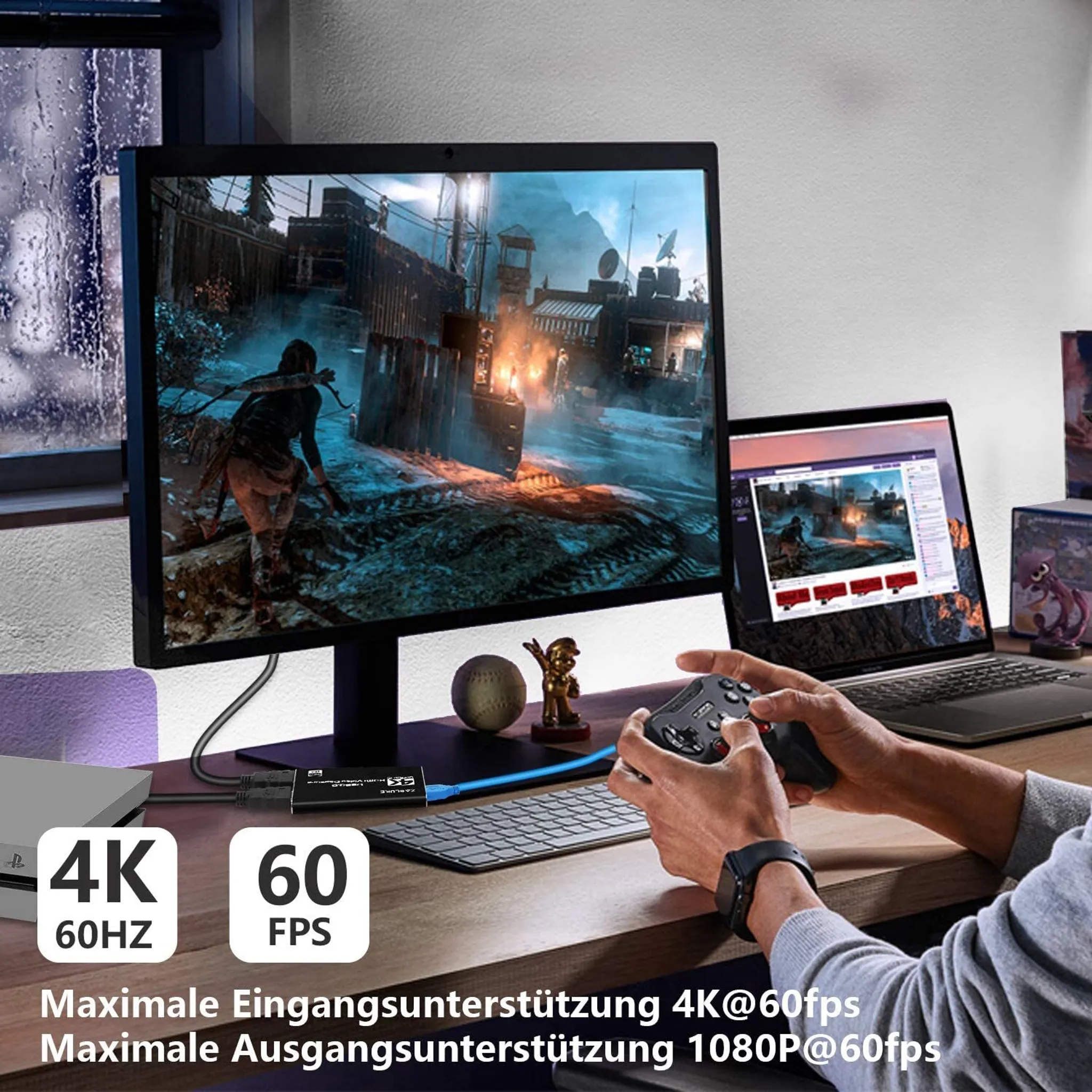 Ein Mann spielt Videospiele auf einem Monitor, ein Laptop daneben.