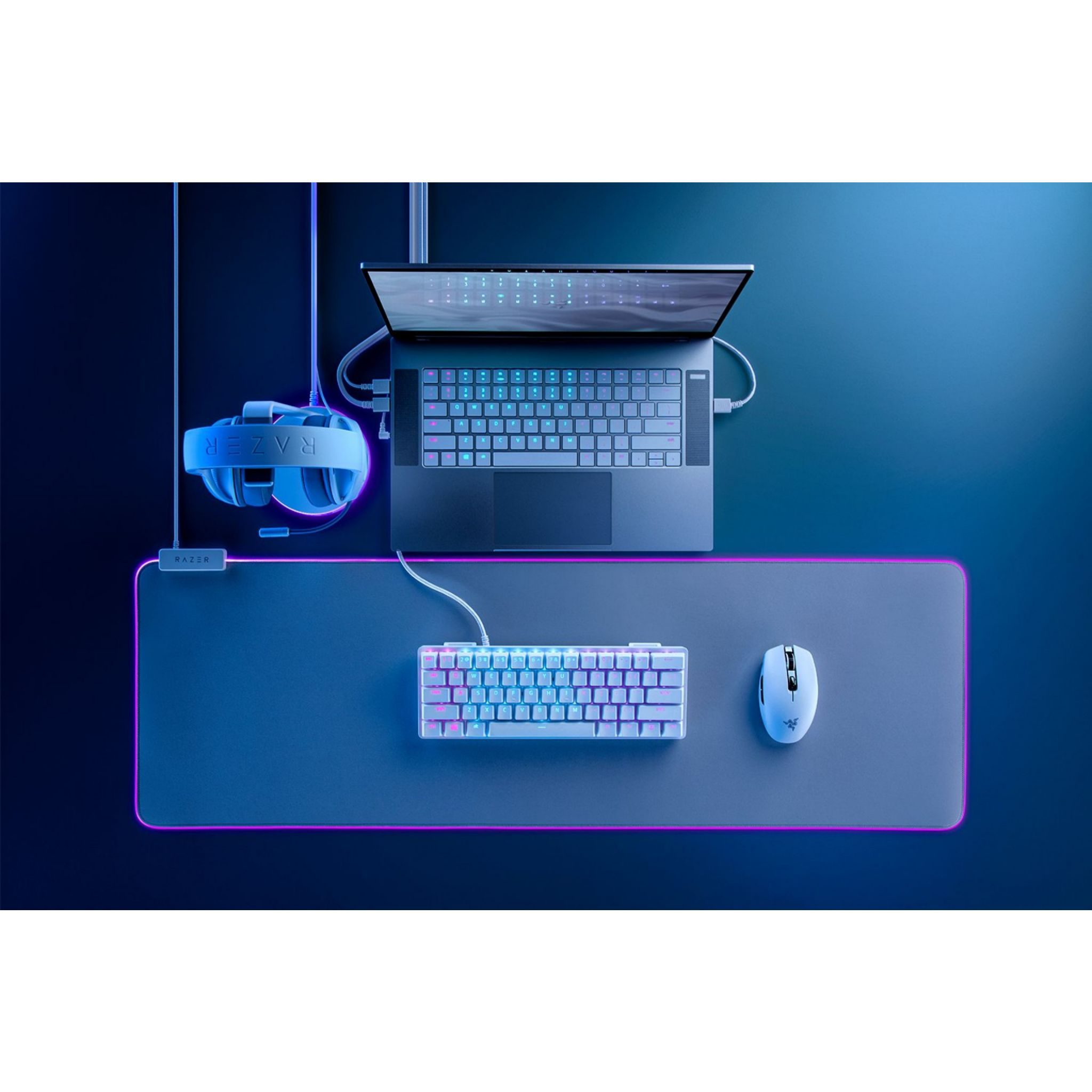 Laptop, klawiatura, mysz i słuchawki na podkładce.