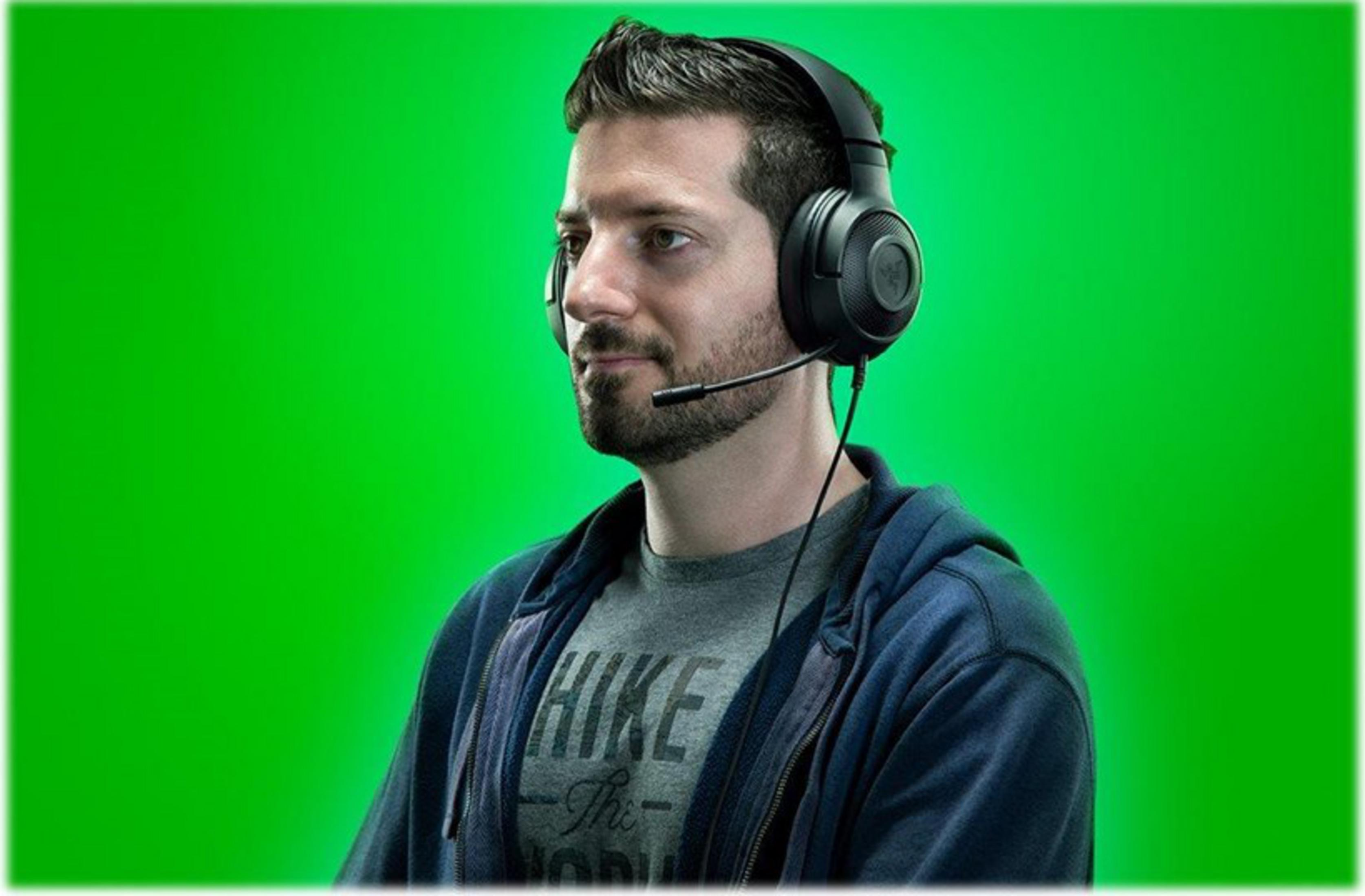 Mężczyzna w słuchawkach z mikrofonem na zielonym tle.