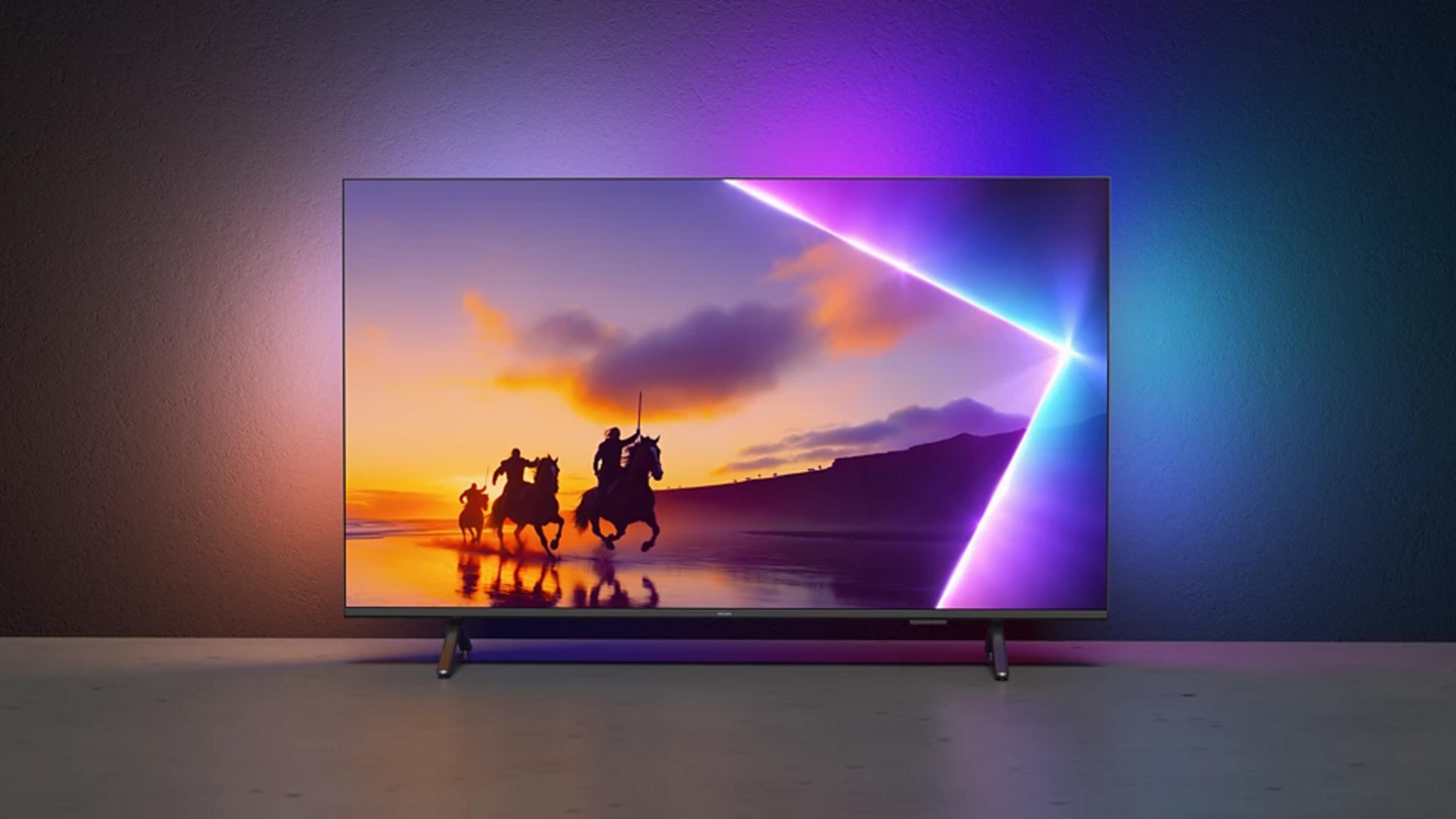 Tres jinetes a caballo en una playa al atardecer, con iluminación Ambilight.