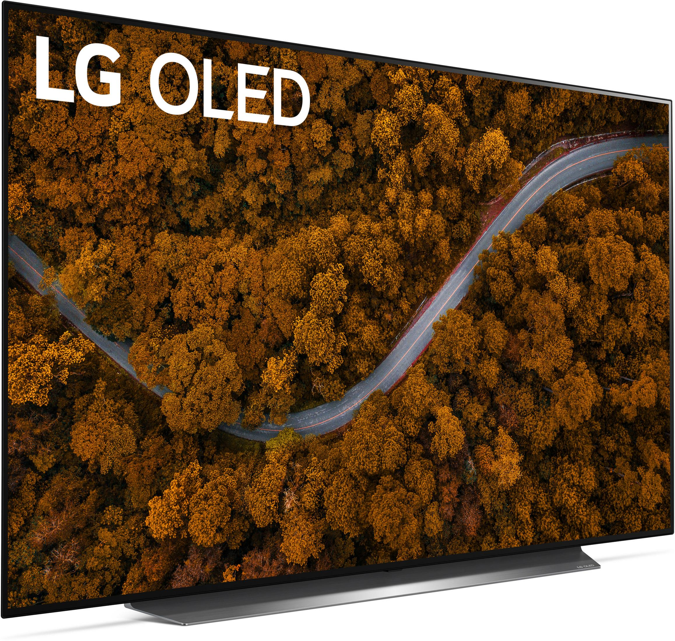 Telewizor LG OLED wyświetla widok z lotu ptaka na drogę wijącą się przez jesienny las.