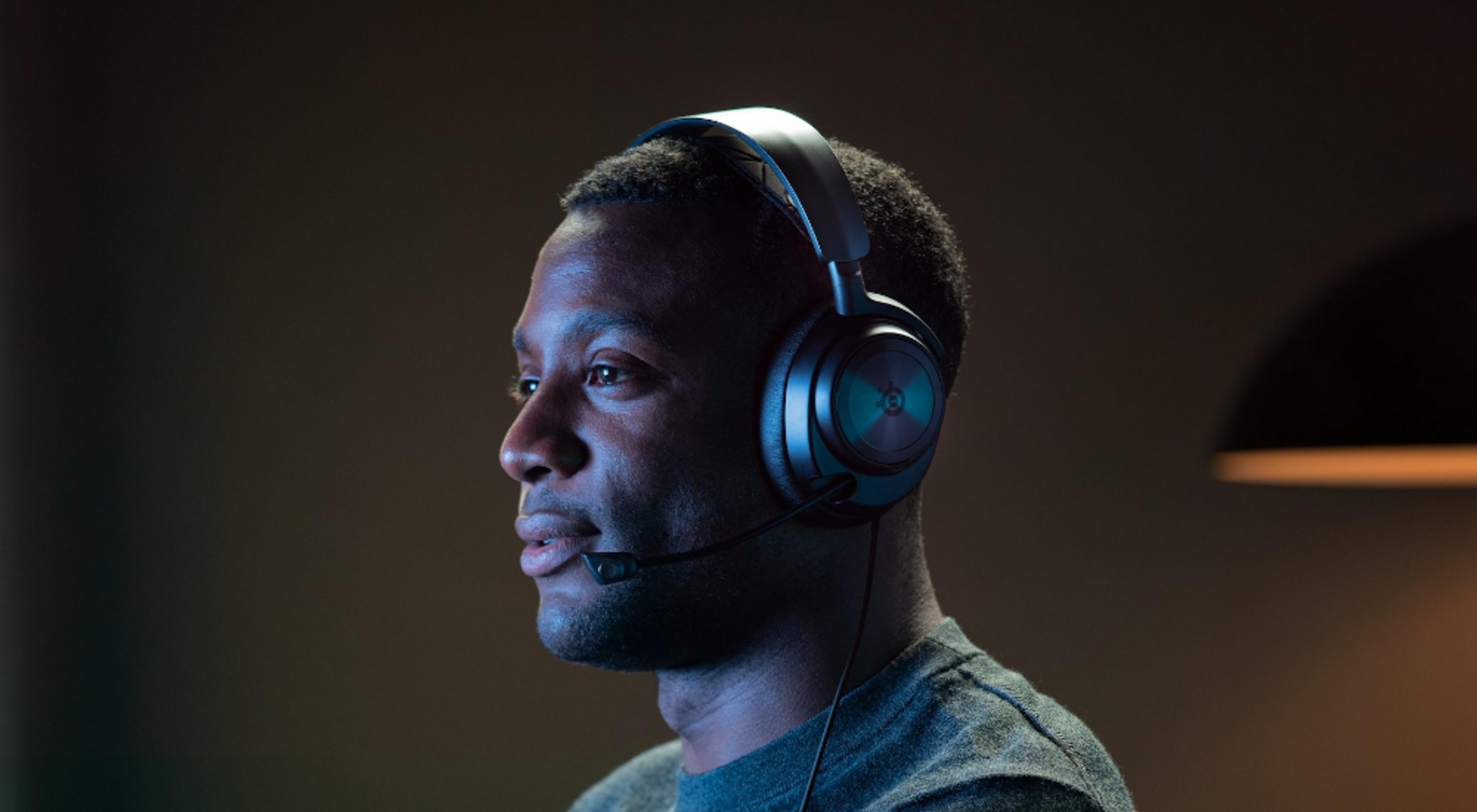 Un hombre con auriculares y micrófono, de perfil sobre fondo oscuro.