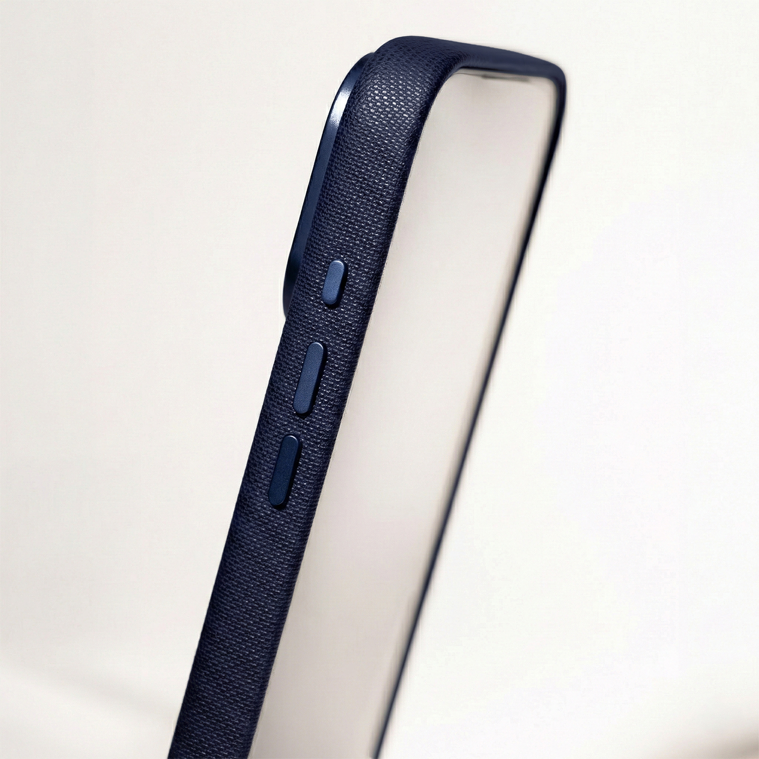 Granatowe etui na telefon z teksturowanej tkaniny z bocznymi przyciskami.