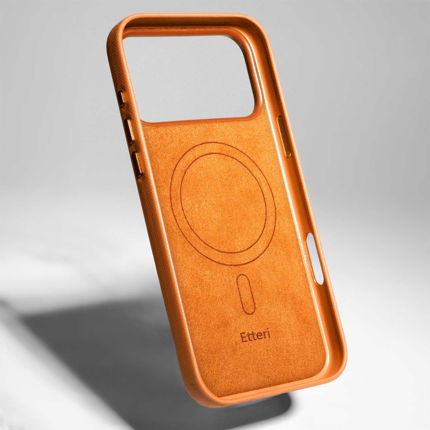 Pomarańczowe etui na telefon z pierścieniem magnetycznym i logo na szarym tle.